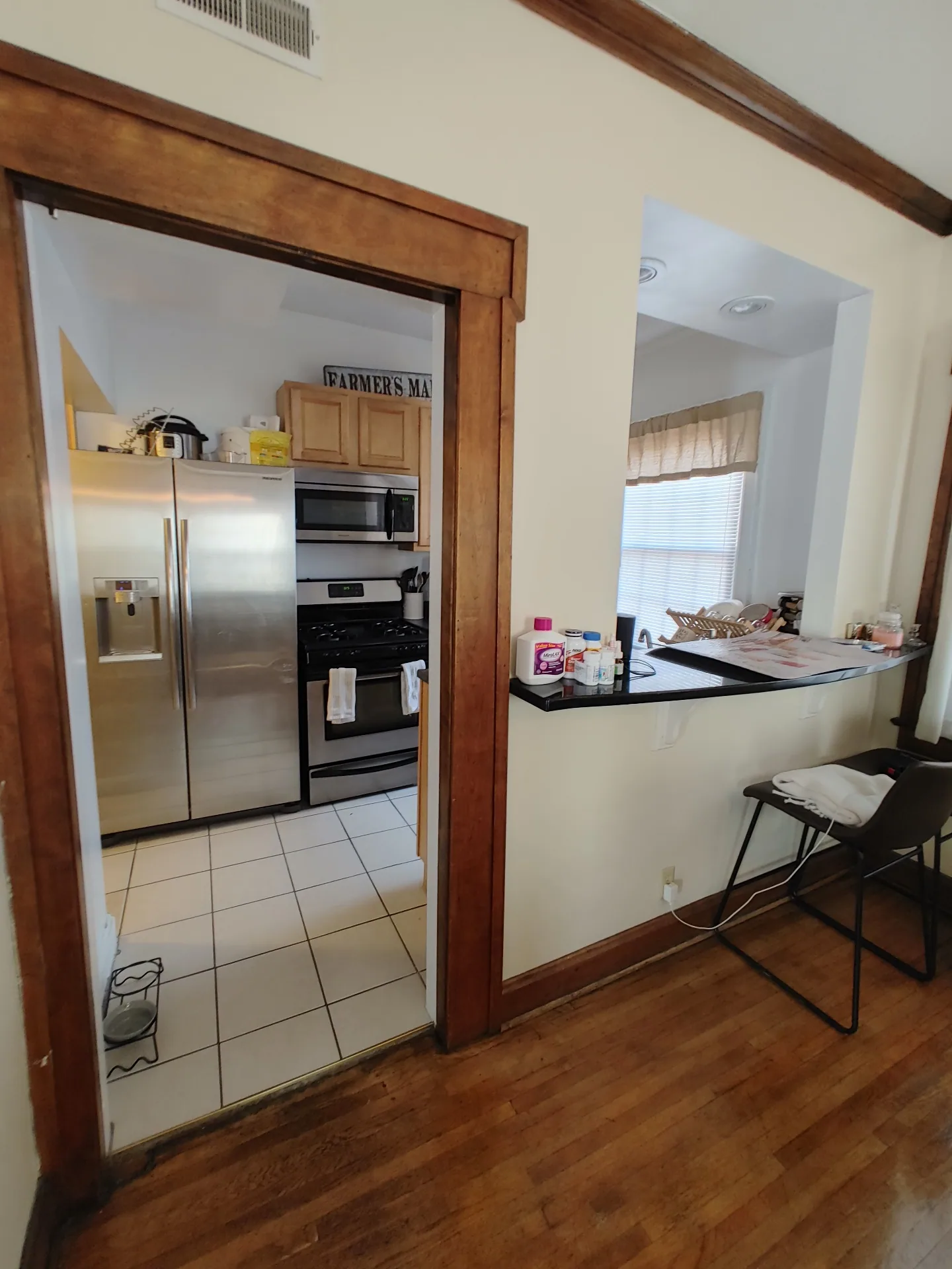 Unit G breakfast bar pass-through into the kitchen with stainless appliances