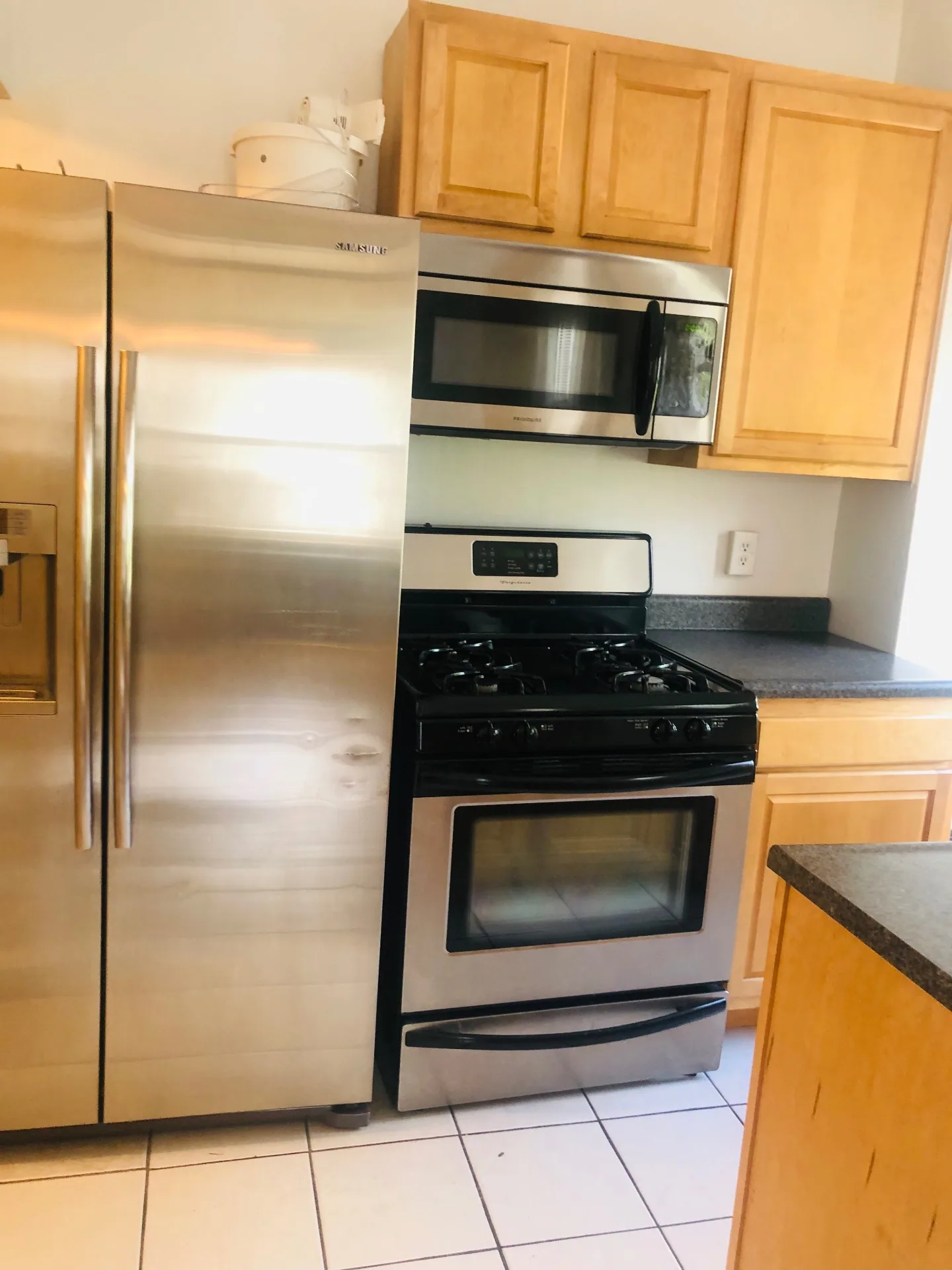 Unit K kitchen with stainless steel Samsung refrigerator, gas range, and microwave