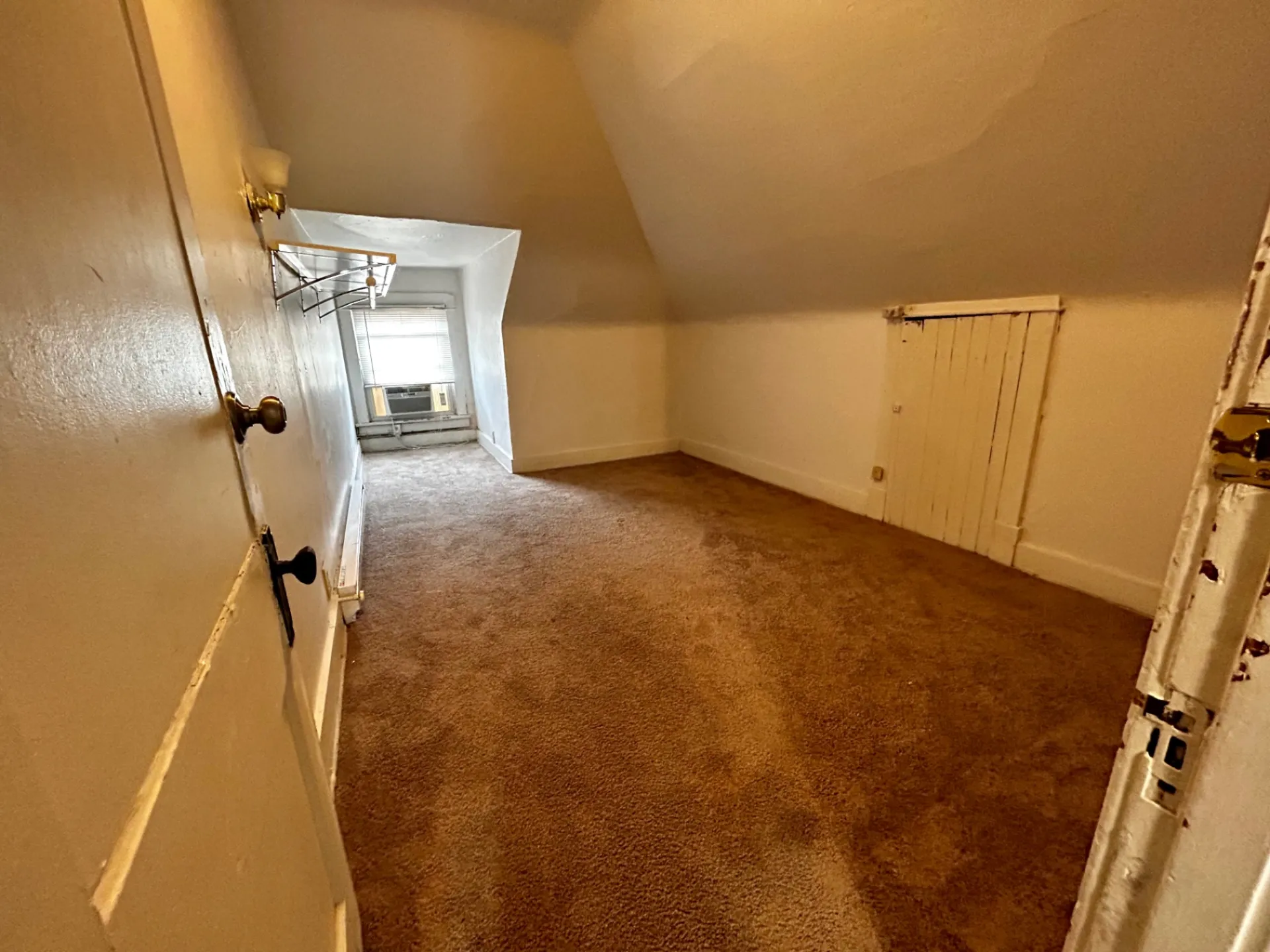 1820 Summit St. upper room with sloped ceilings, fresh carpet, and deep window nook