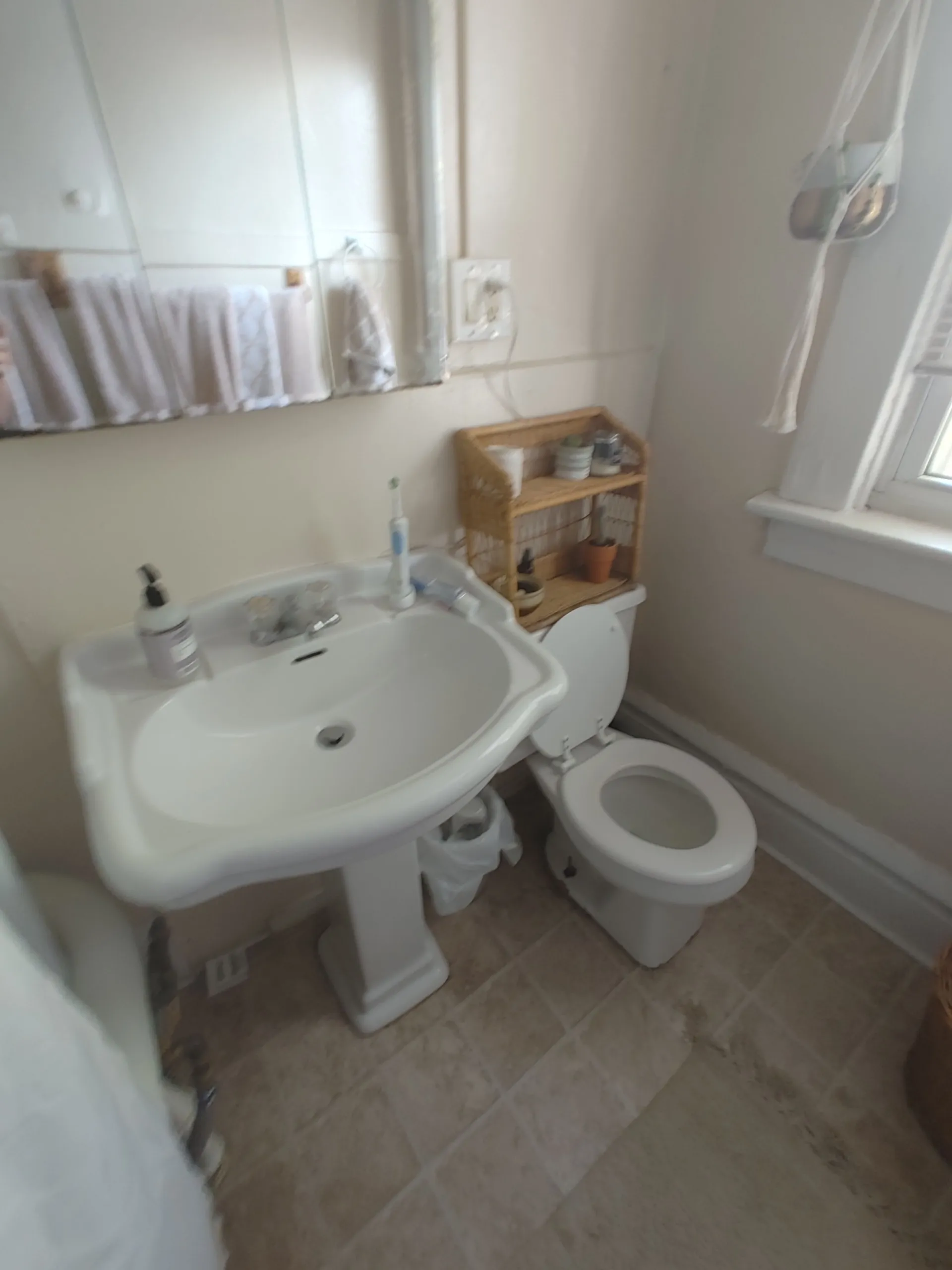 121 W 9th bathroom with pedestal sink, tile floor, and bright window