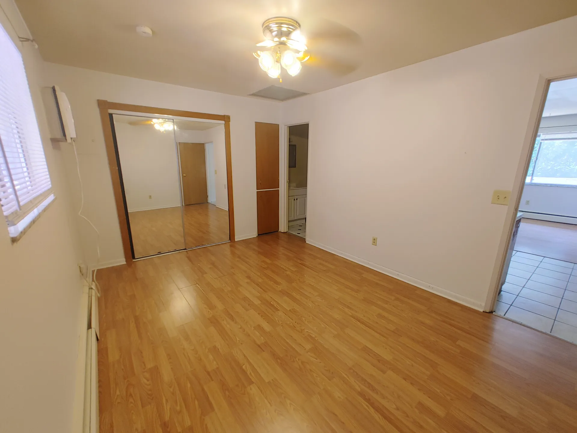 1827 N 4th St. Unit 5 bedroom with wood-look flooring, ceiling fan, and en-suite bath access