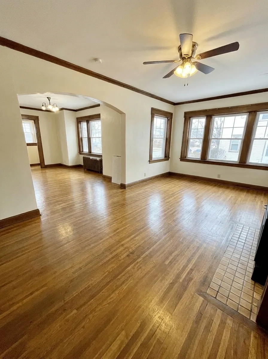 Unit D expansive living room with hardwood floors and dining area beyond