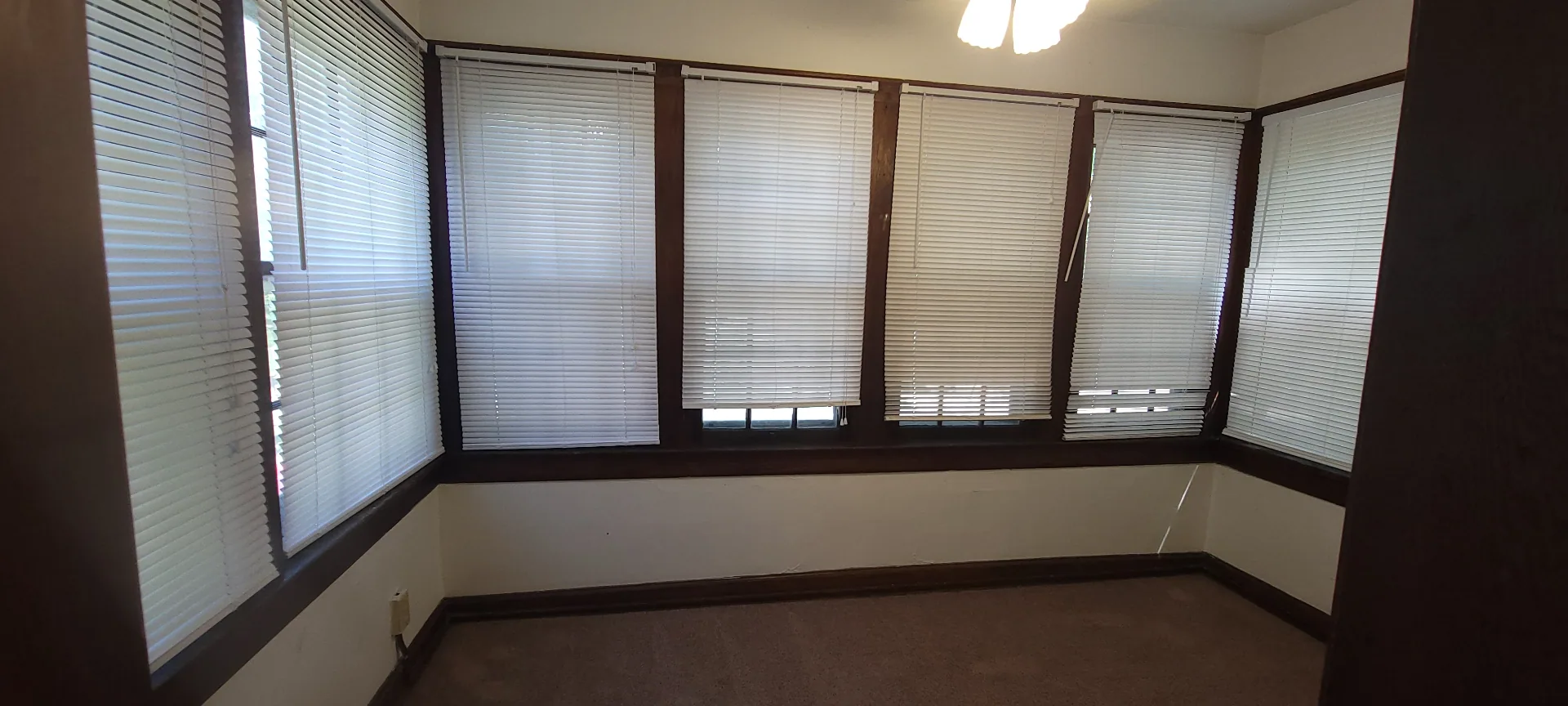 2054 Iuka Ave. C sunroom lined with windows on three sides — bright, versatile flex space