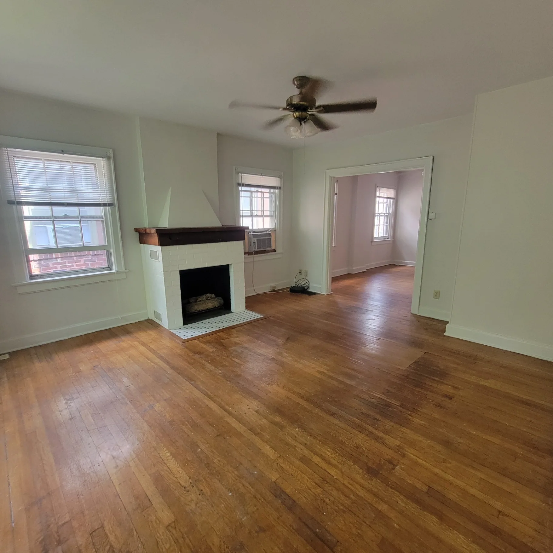 2048 Iuka Ave. C living room with fireplace, ceiling fan, and bright front windows