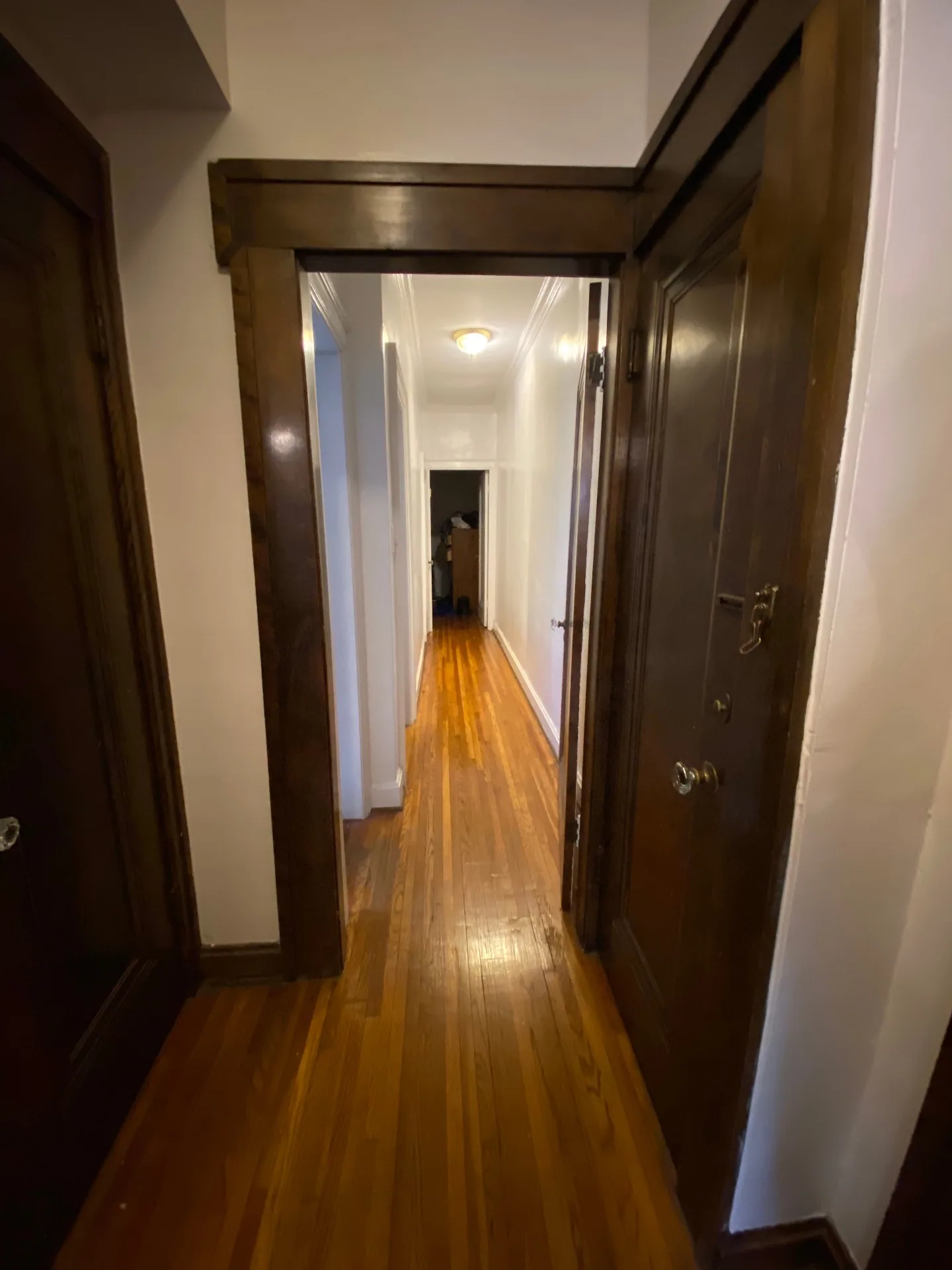Unit E hallway with dark wood trim and hardwood floors