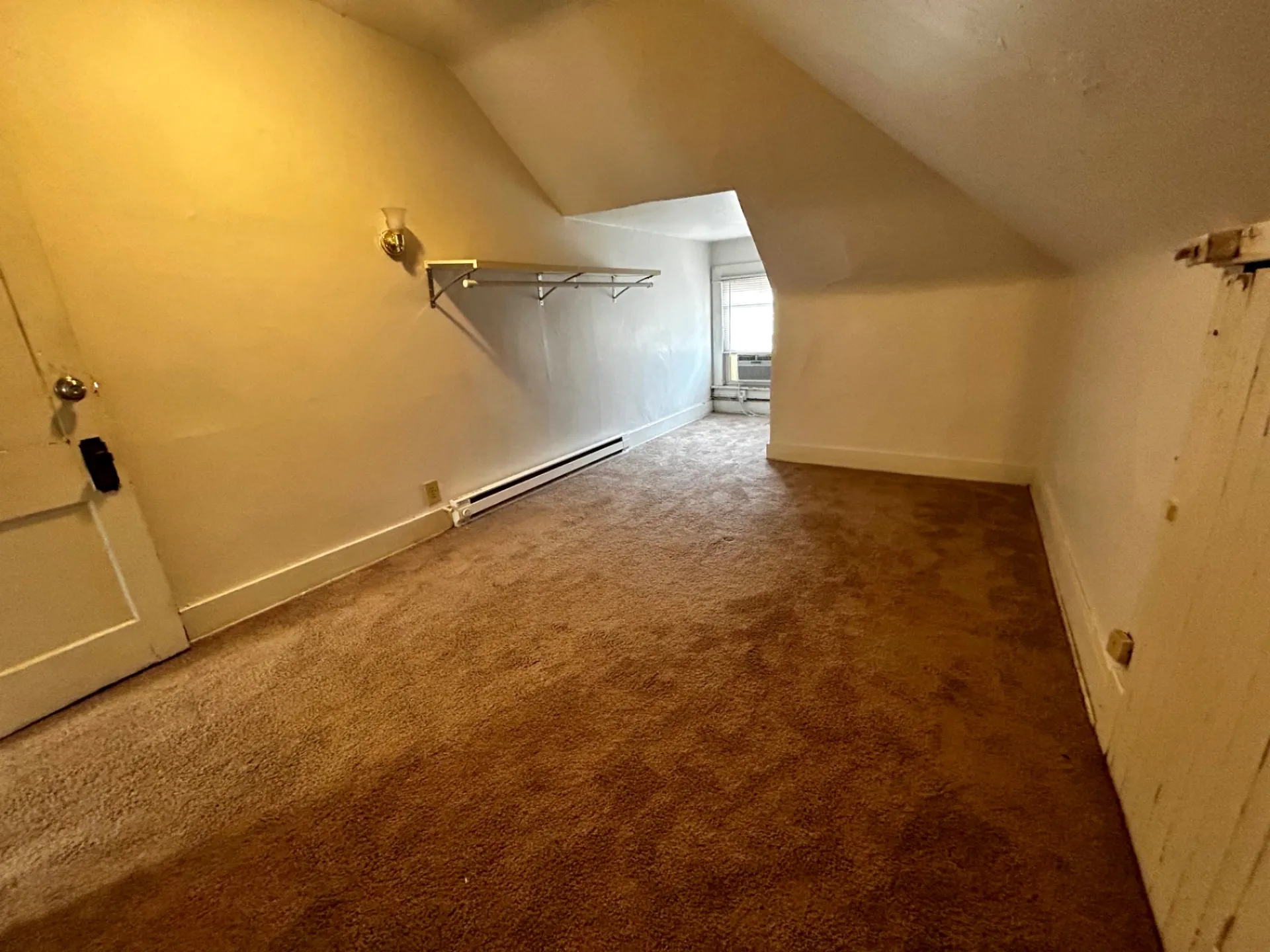 1820 Summit St. upper room with sloped ceilings, fresh carpet, and bright window AC nook