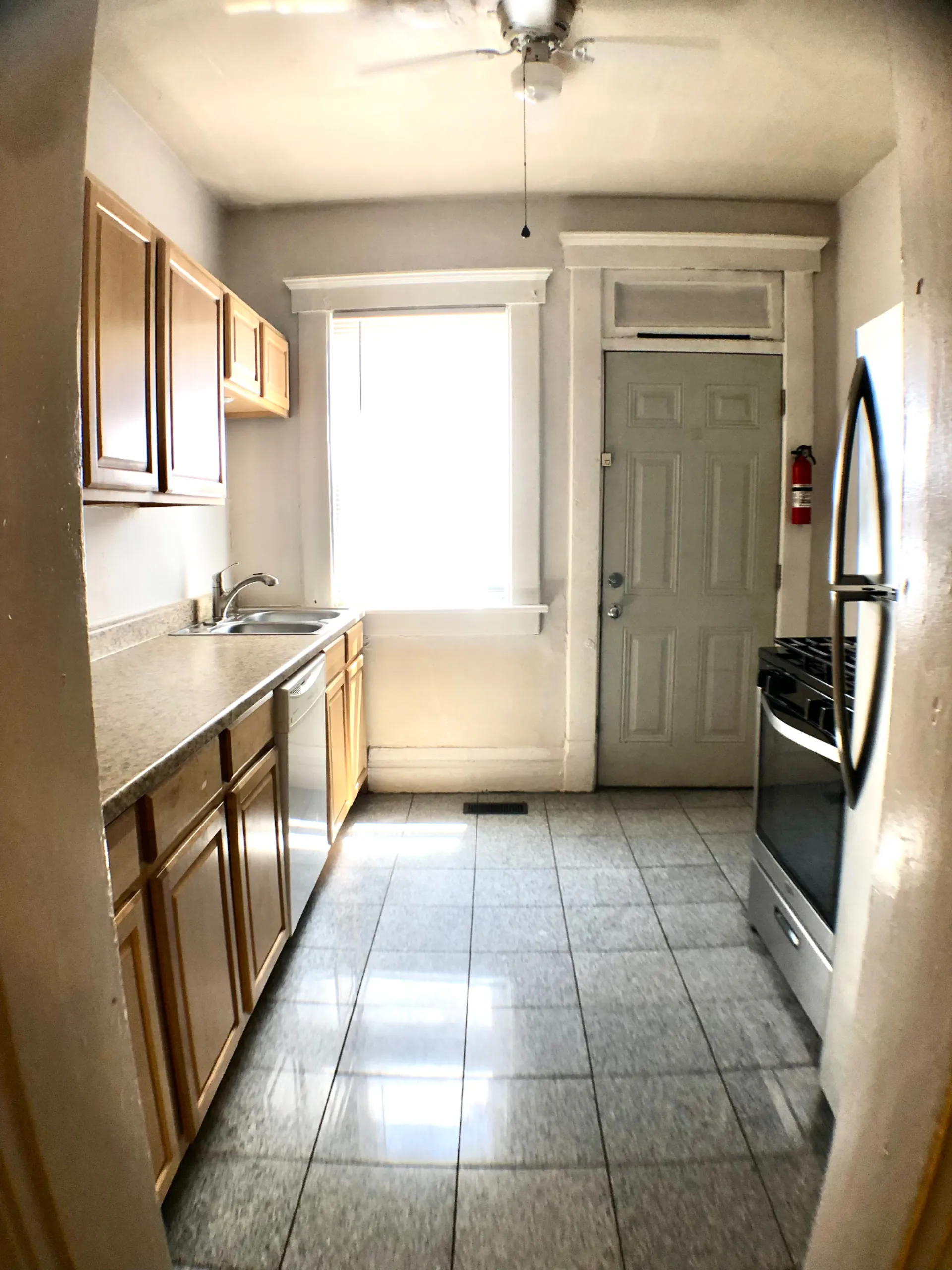 117 W 9th galley kitchen with stainless gas range, dishwasher and side door