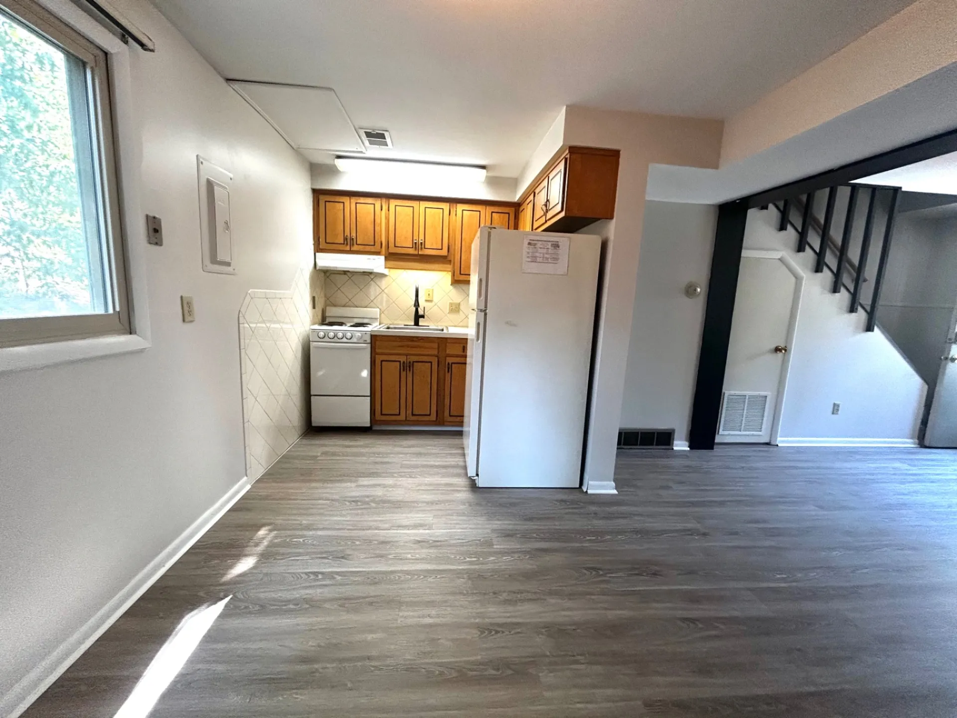 2011 Summit St. Unit E kitchen area with wood cabinets, white appliances, and large window