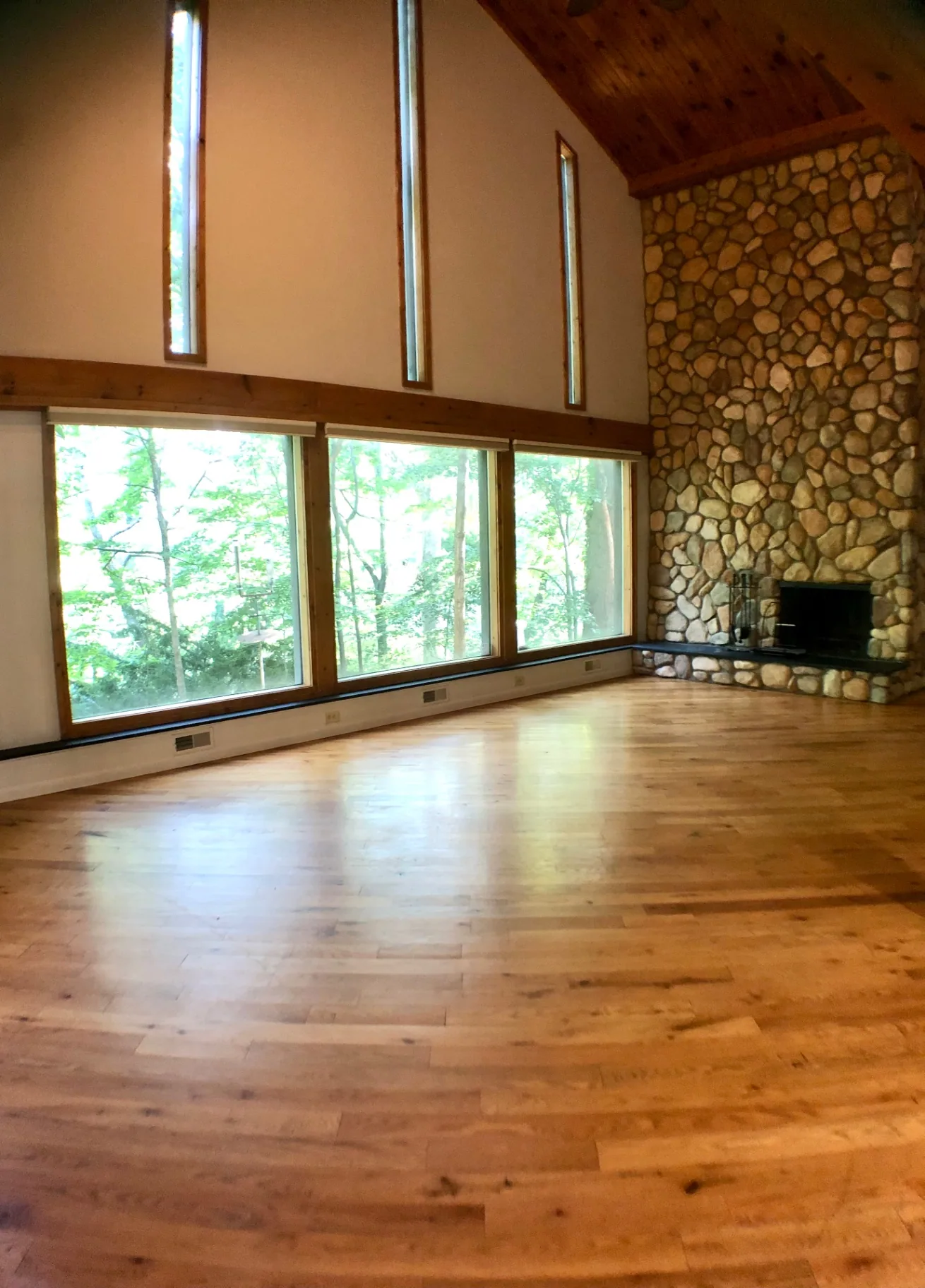 2040 Iuka Ave House great room with wall of ravine-view windows and river-stone fireplace