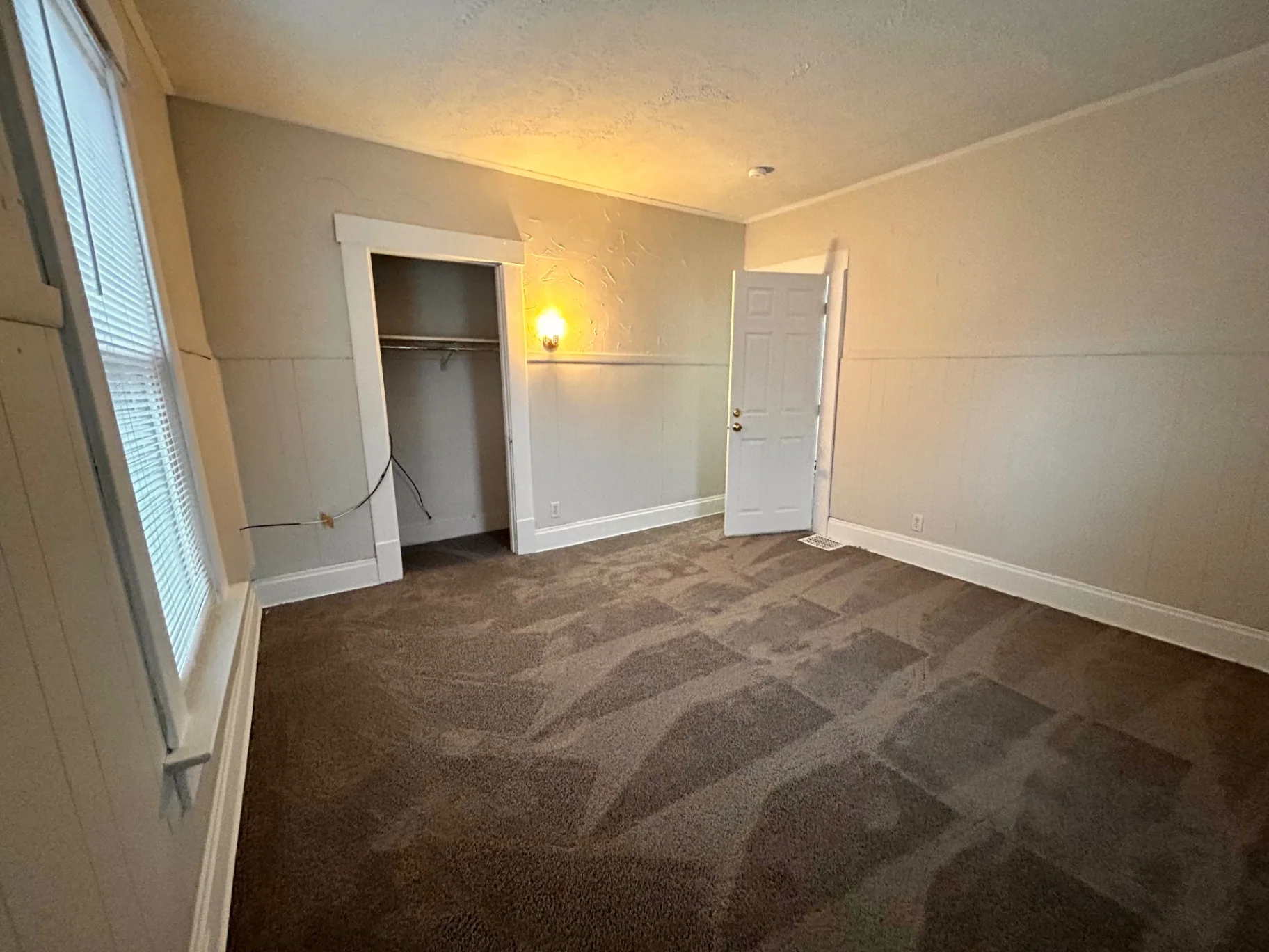 68 E Patterson Ave. bedroom with reach-in closet, wall sconce, and wainscot trim