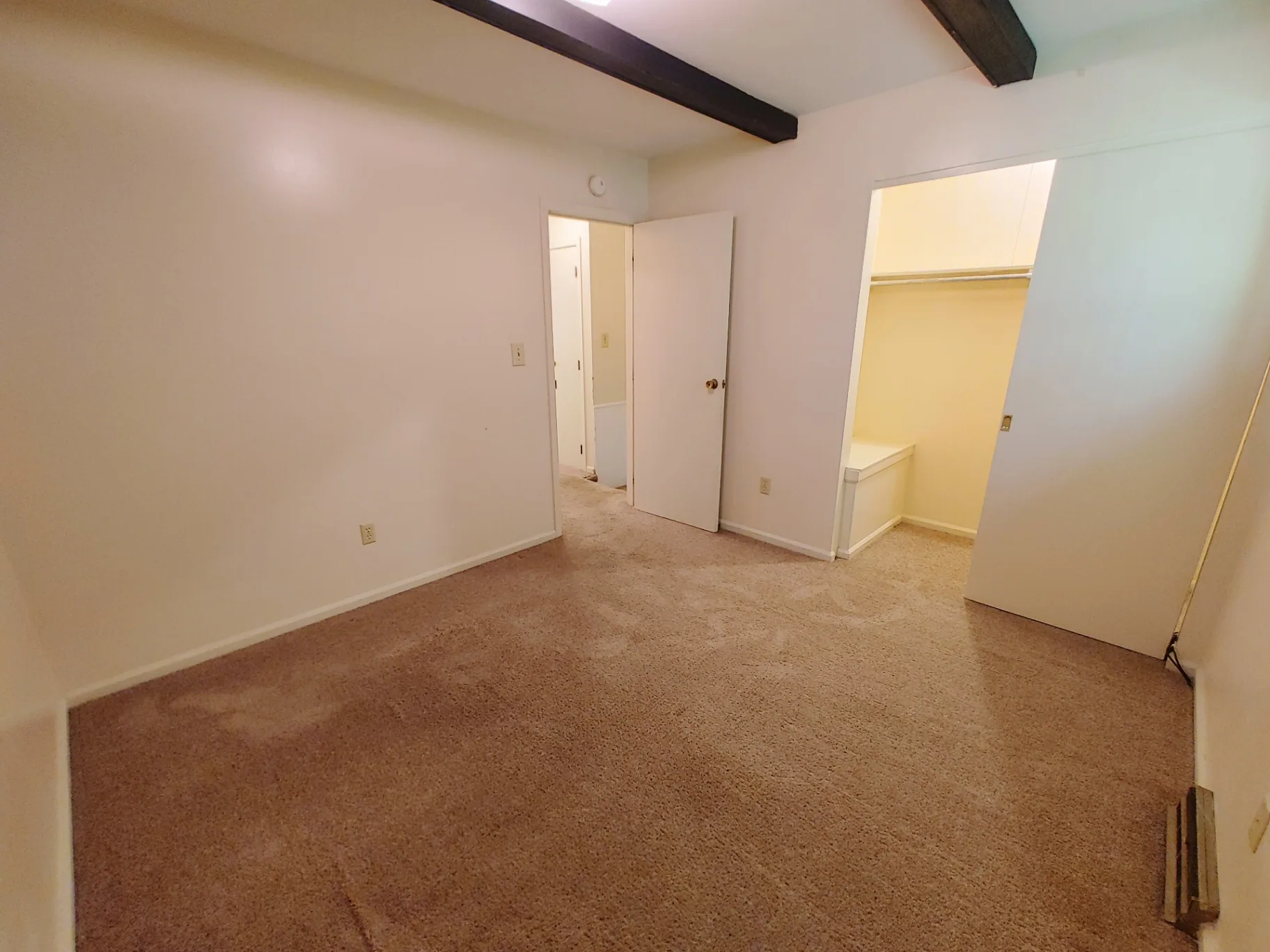 2018 Iuka Ave. carpeted bedroom with walk-in closet and exposed ceiling beams