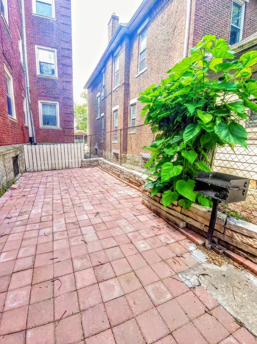 Communal brick patio with charcoal grill at Flats on Neil