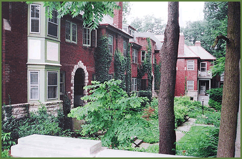 2054 Iuka Ave. historic red-brick building exterior with green trim and lush ravine landscaping