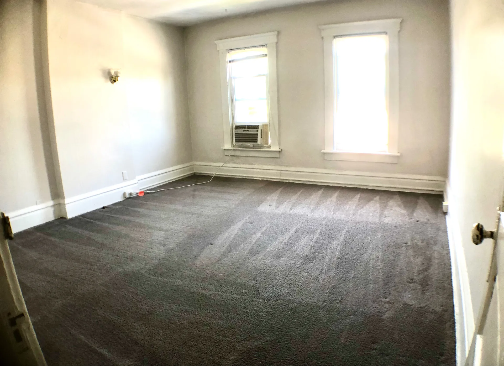 117 W 9th bedroom with fresh grey carpet and two bright windows