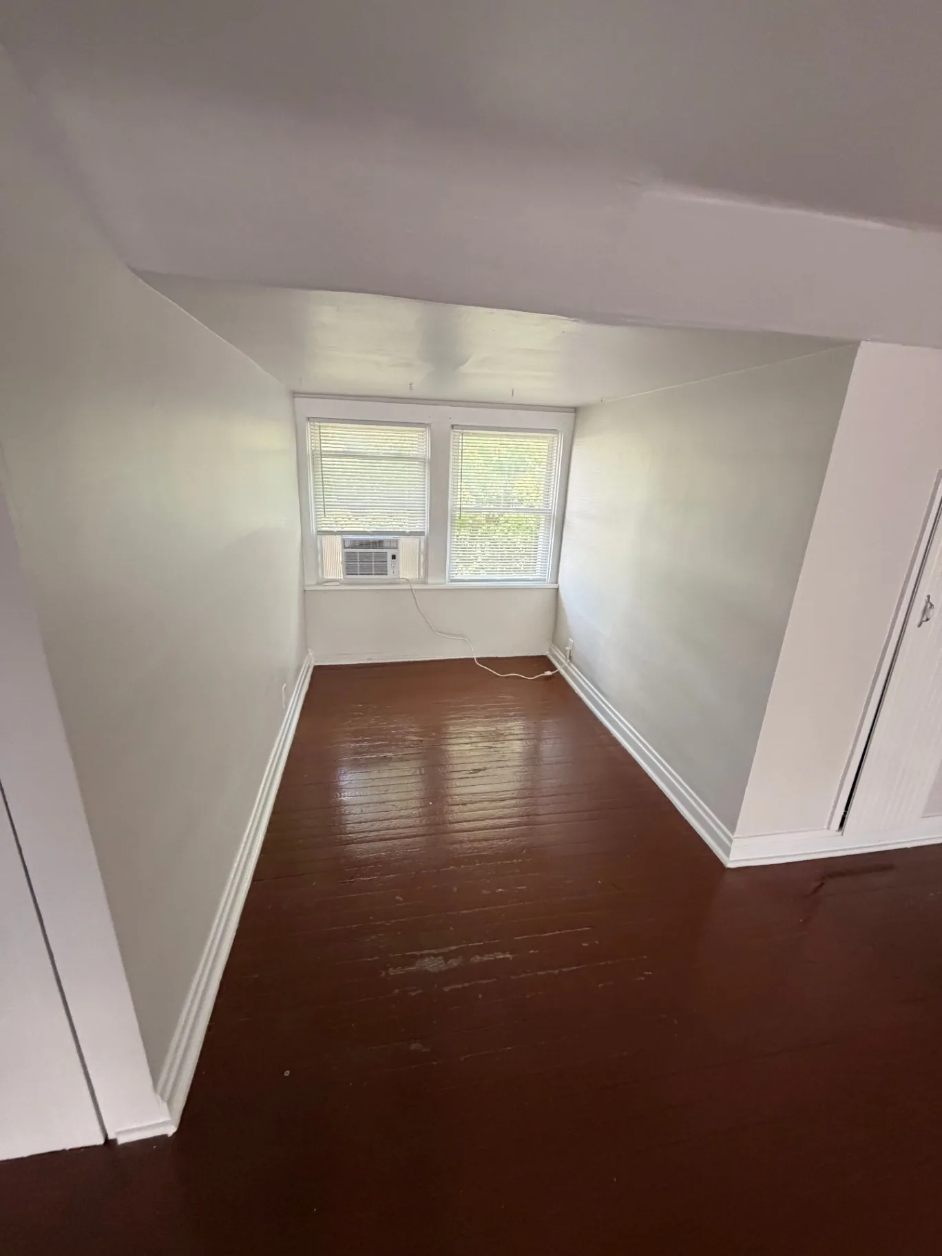 3340 Chestnut Upstairs bedroom nook with painted hardwood floors and window AC
