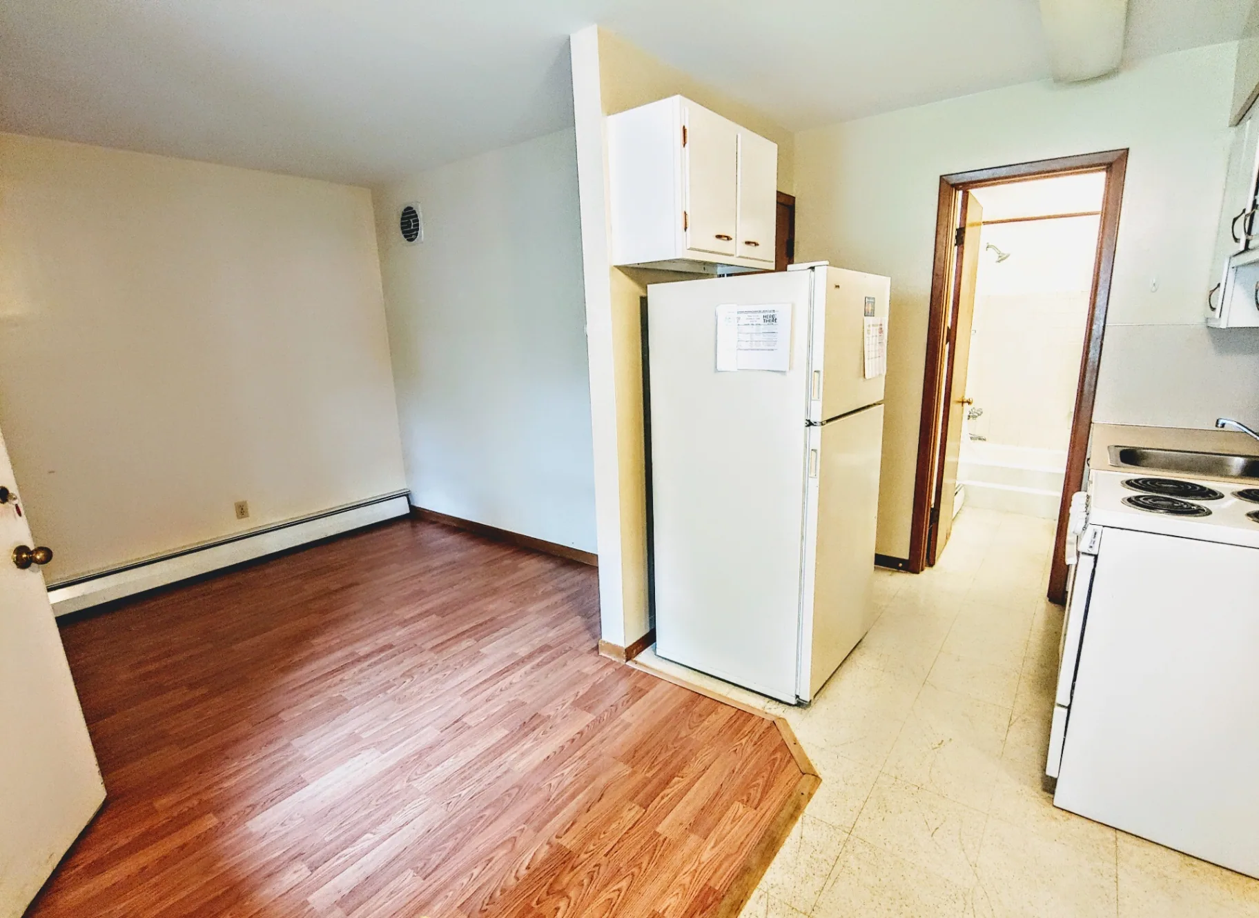 2040 Iuka Ave 4B kitchen and entry view with white appliances and laminate floors