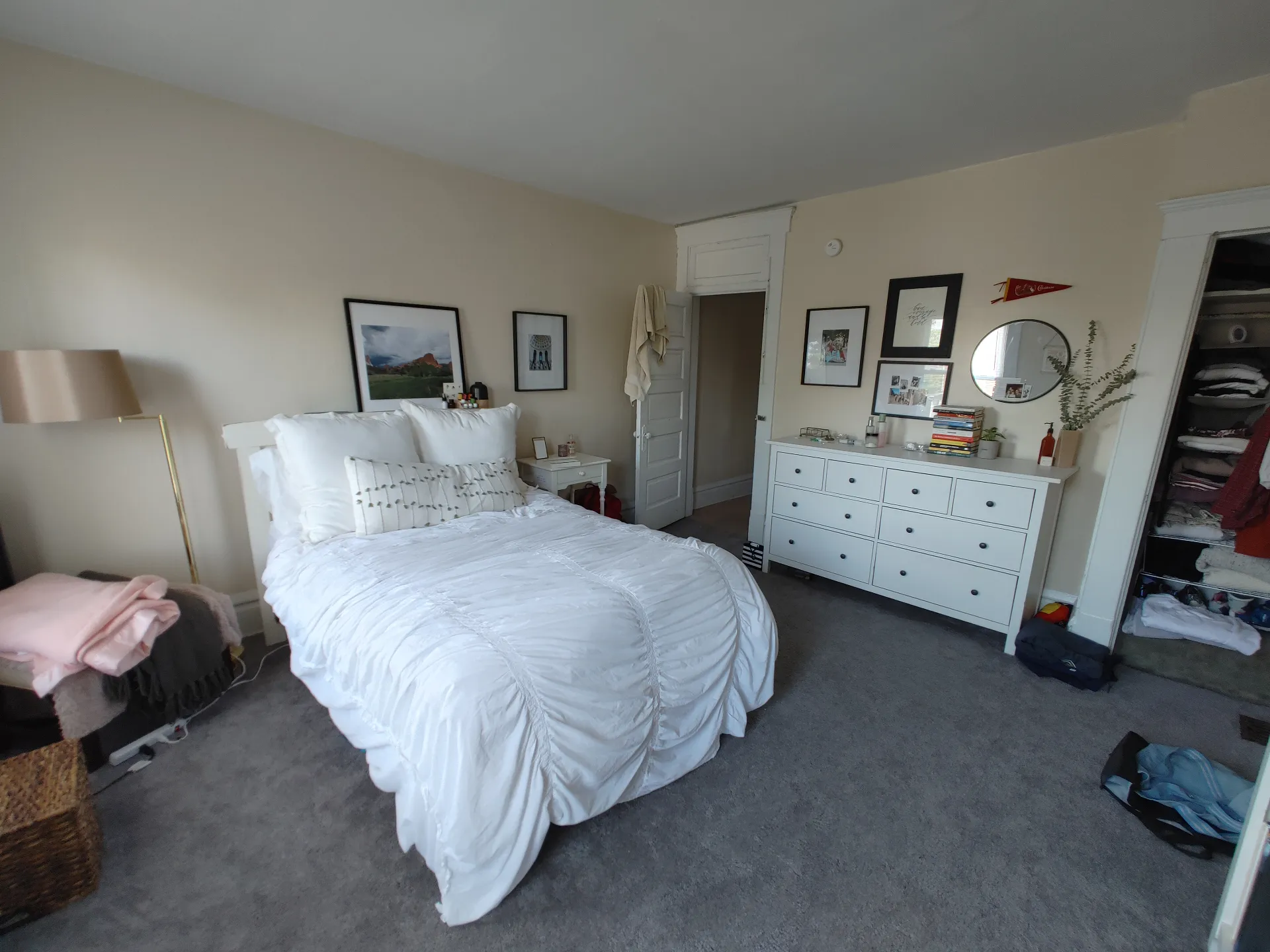 121 W 9th spacious staged bedroom with white bed, dresser, and plush carpet