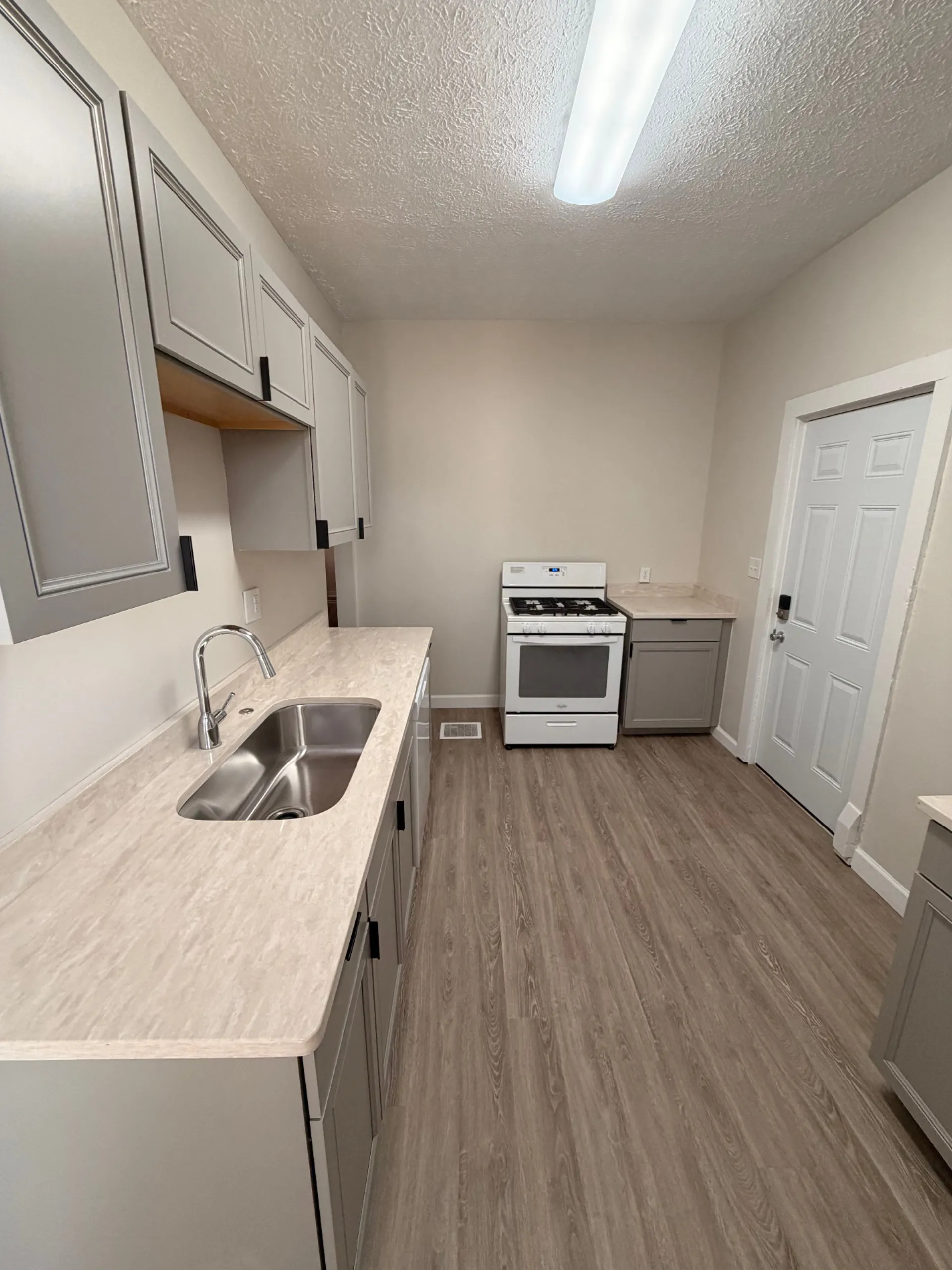133½ galley kitchen with new gas range and plank flooring