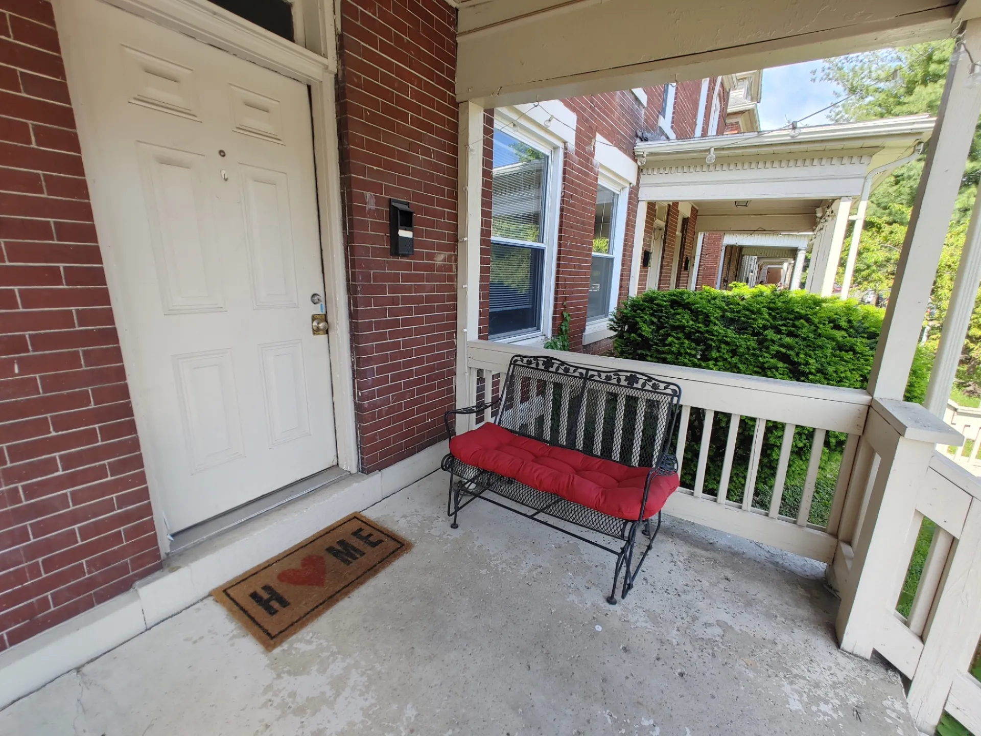121 W 9th covered brick front porch with wrought iron bench