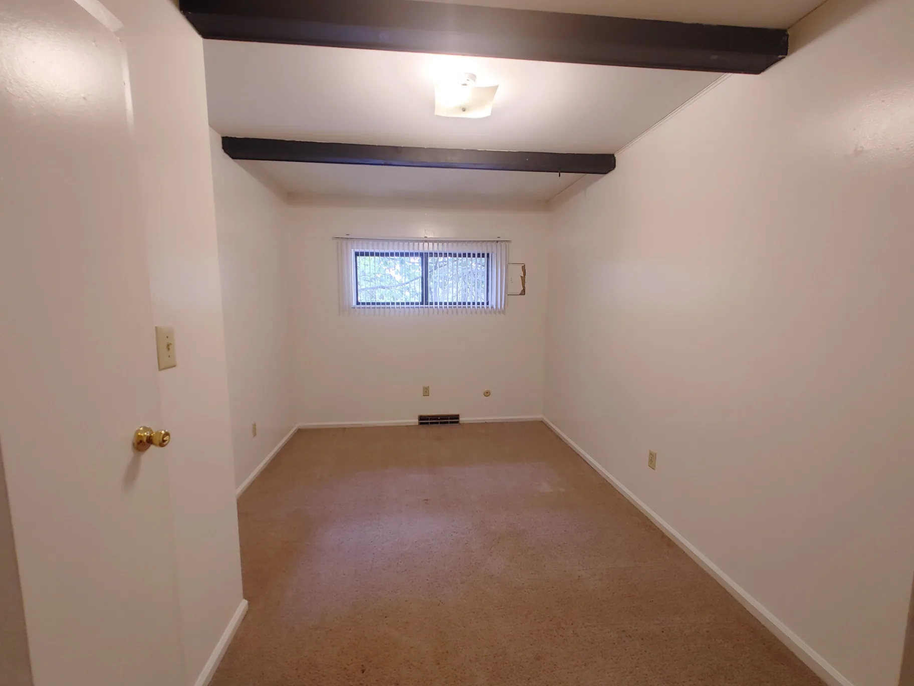 2016 Iuka Ave. bedroom with exposed beams and a wide carpeted layout