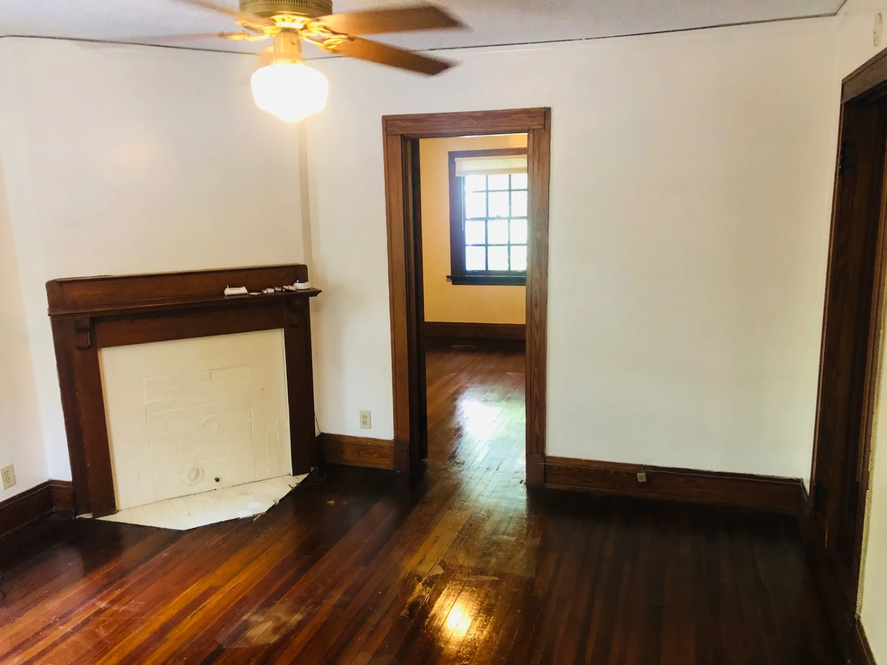 2026 Iuka Ave C living room with vintage wood mantel, ceiling fan, and refinished hardwood floors