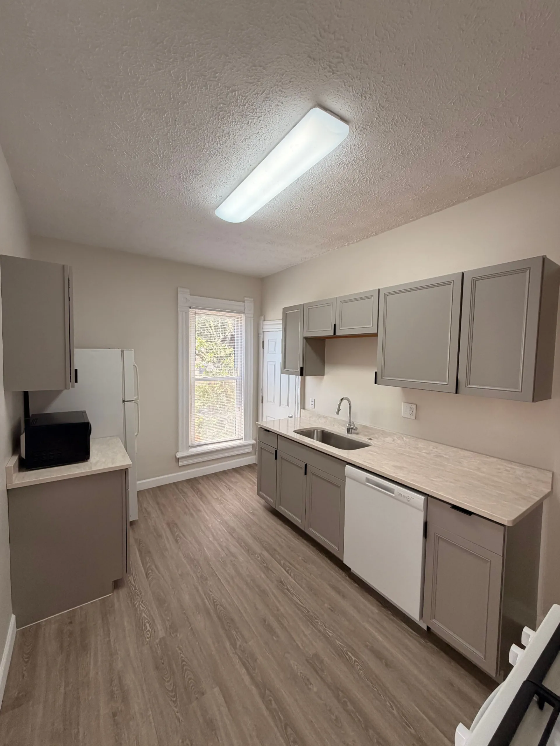 133½ renovated kitchen with grey cabinets, quartz counters and stainless sink