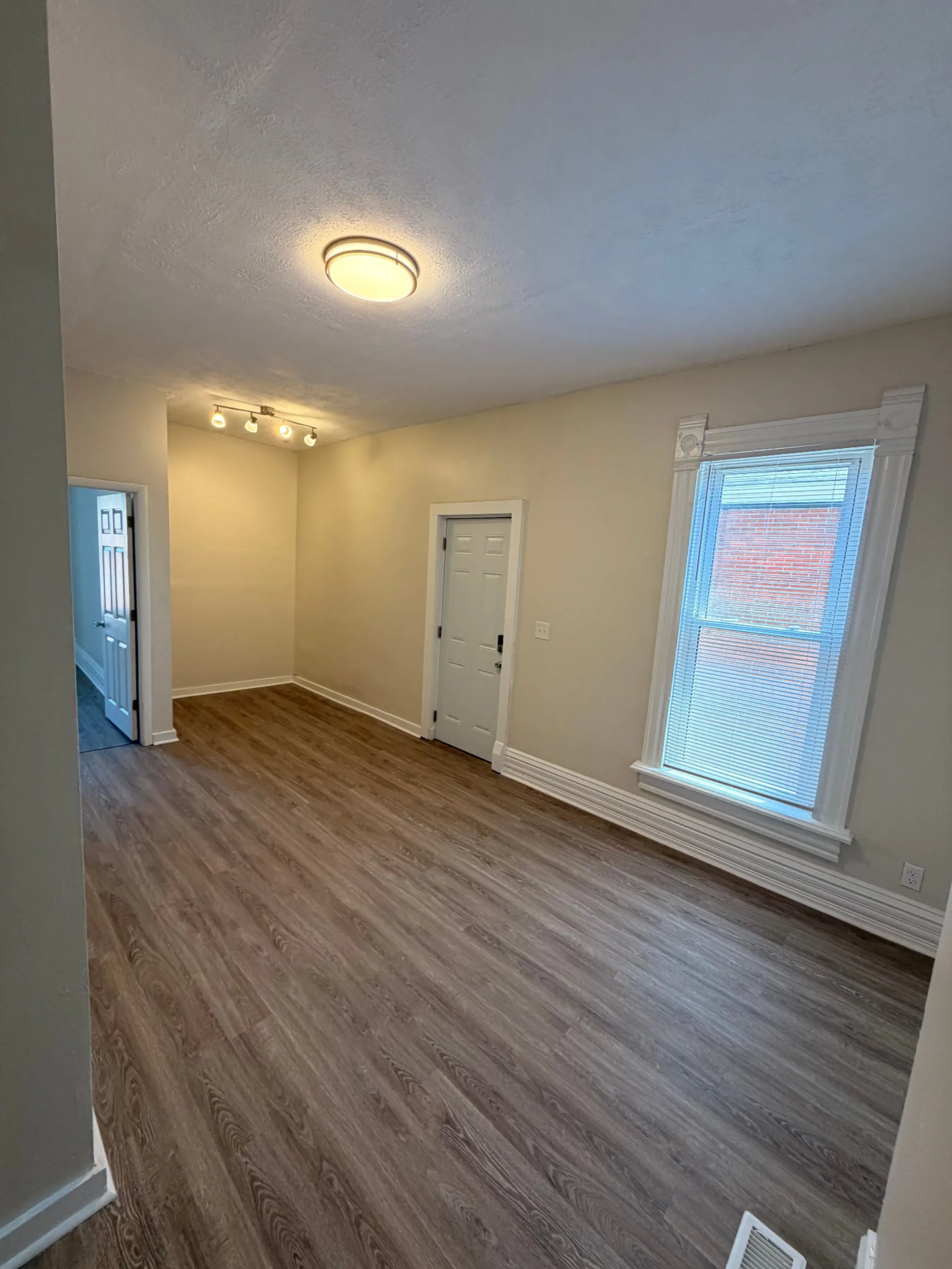 133½ bright living room with plank flooring, tall trim and private entry door