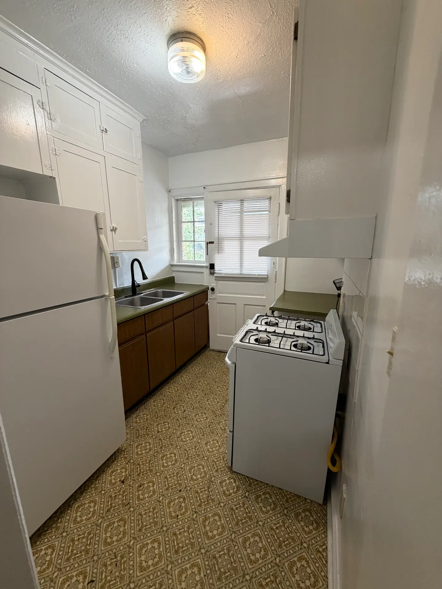 2048 Iuka Ave. D galley kitchen with gas range, double sink, full-size refrigerator, and rear door