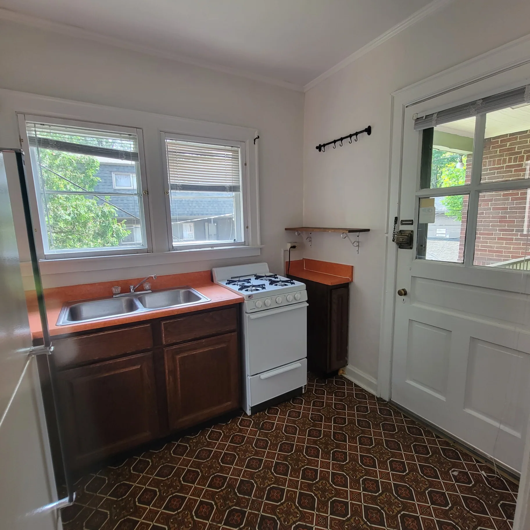 2048 Iuka Ave. C kitchen with gas range, rear door, and bright windows above the sink