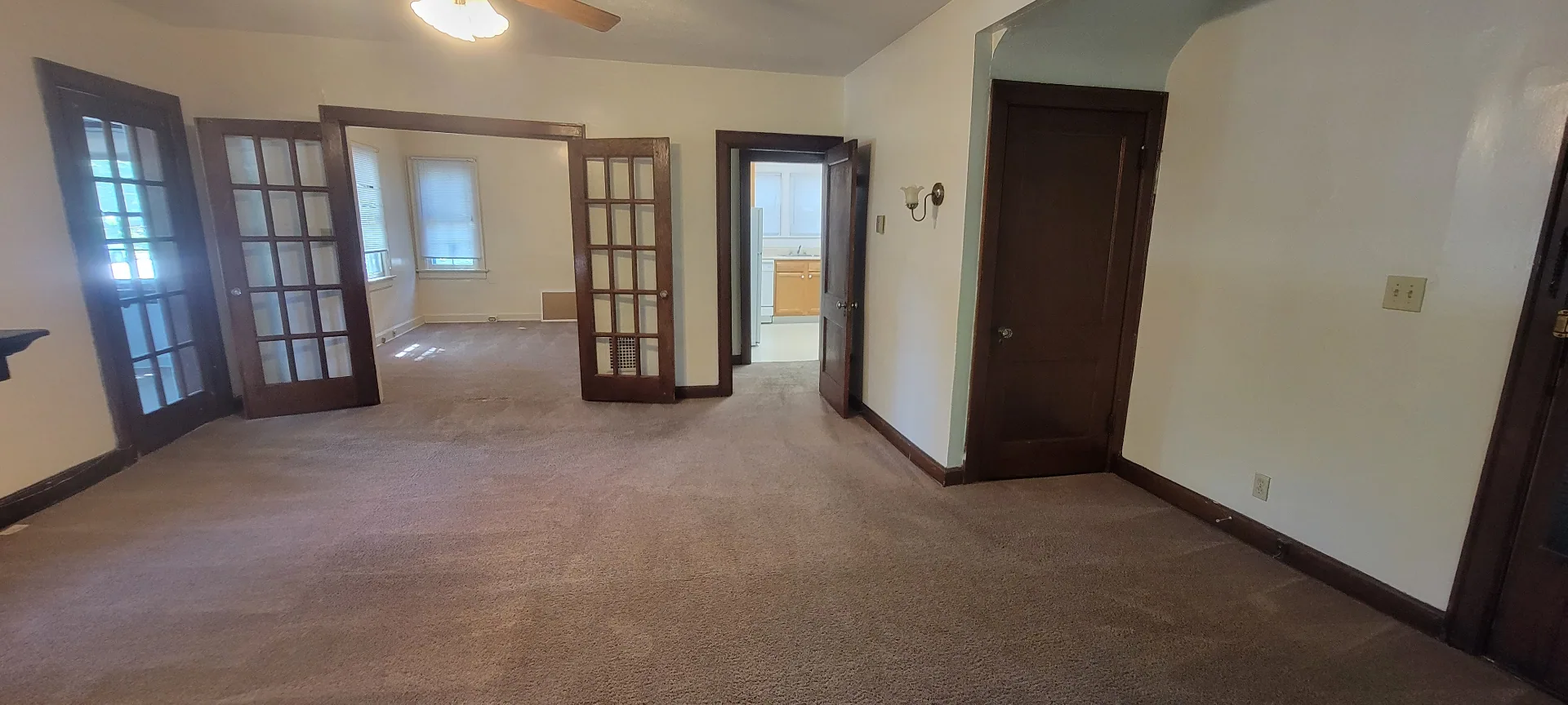 2054 Iuka Ave. A living area with original French doors and dark wood trim