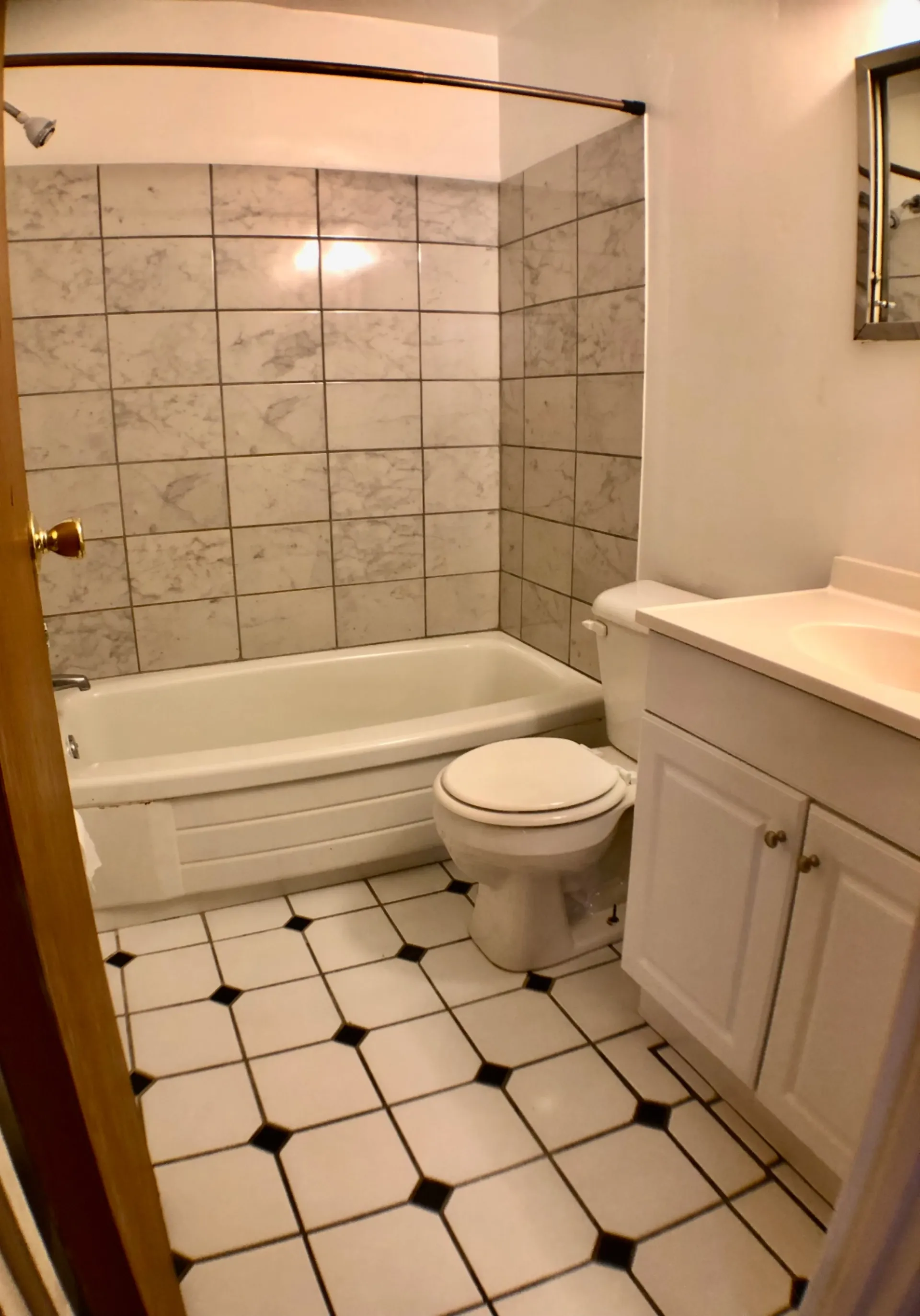 1827 N 4th St. Unit 1 bathroom with marble-tiled tub surround and checkered tile floor
