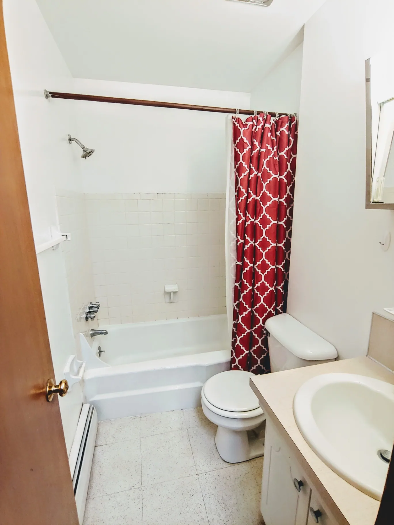 2040 Iuka Ave 4B bathroom with tub shower, vanity, and patterned curtain