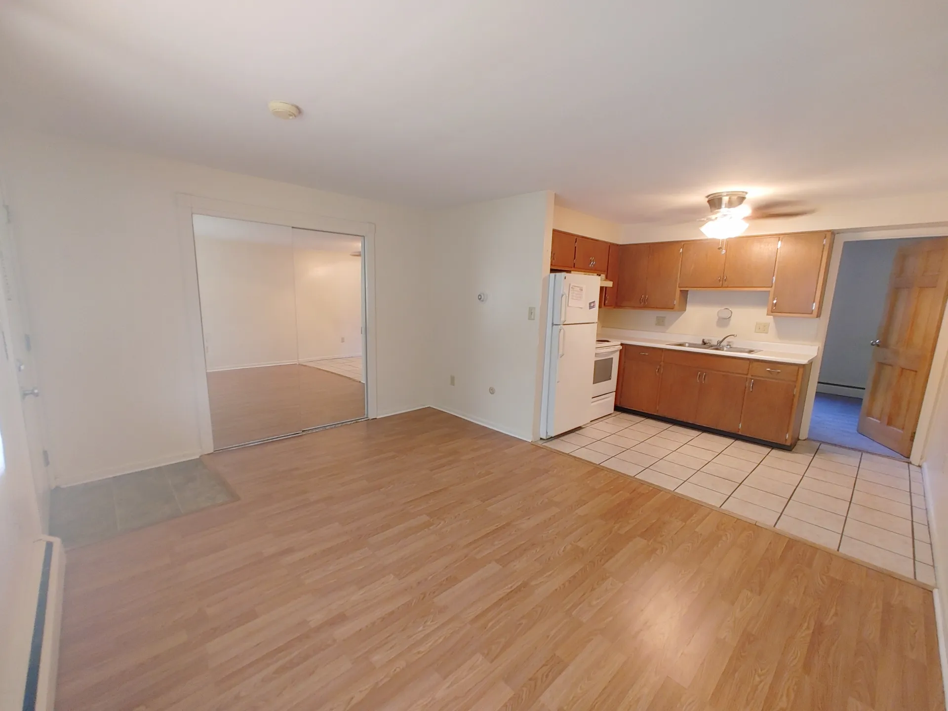 1827 N 4th St. Unit 3 open living area with wood-look flooring, mirrored closet doors, and kitchen