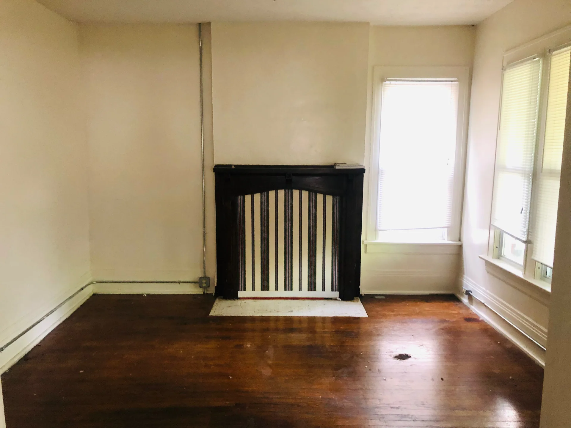 2005 Summit St. bedroom with dark wood decorative fireplace mantel and hardwood floors