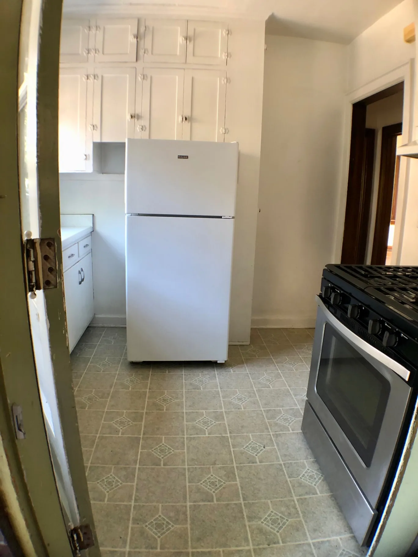 2044 Iuka Ave. A kitchen with white cabinets, stainless gas range, and full-size refrigerator
