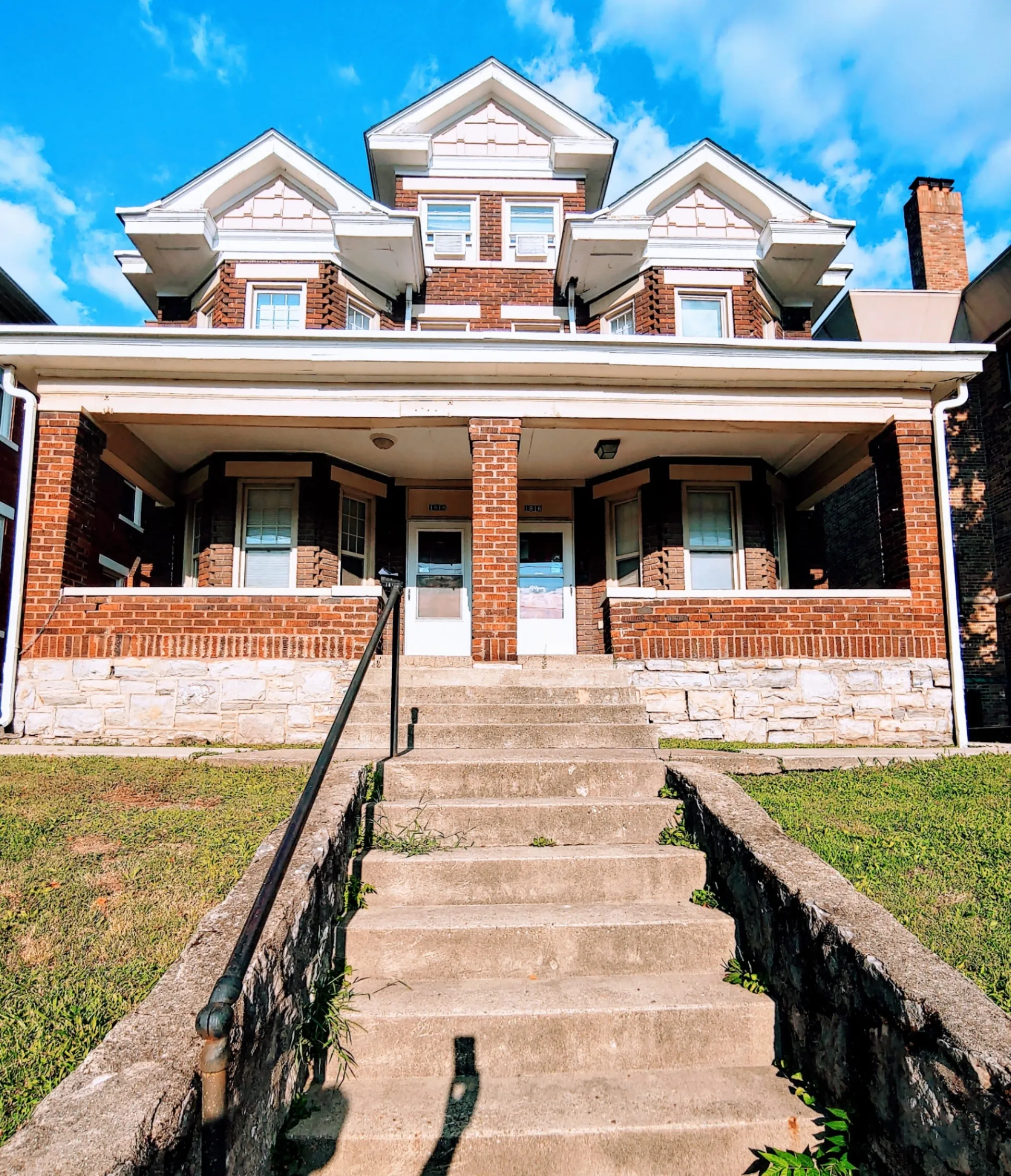 1818 Summit St. brick exterior with covered porch, dormer windows, and stone foundation