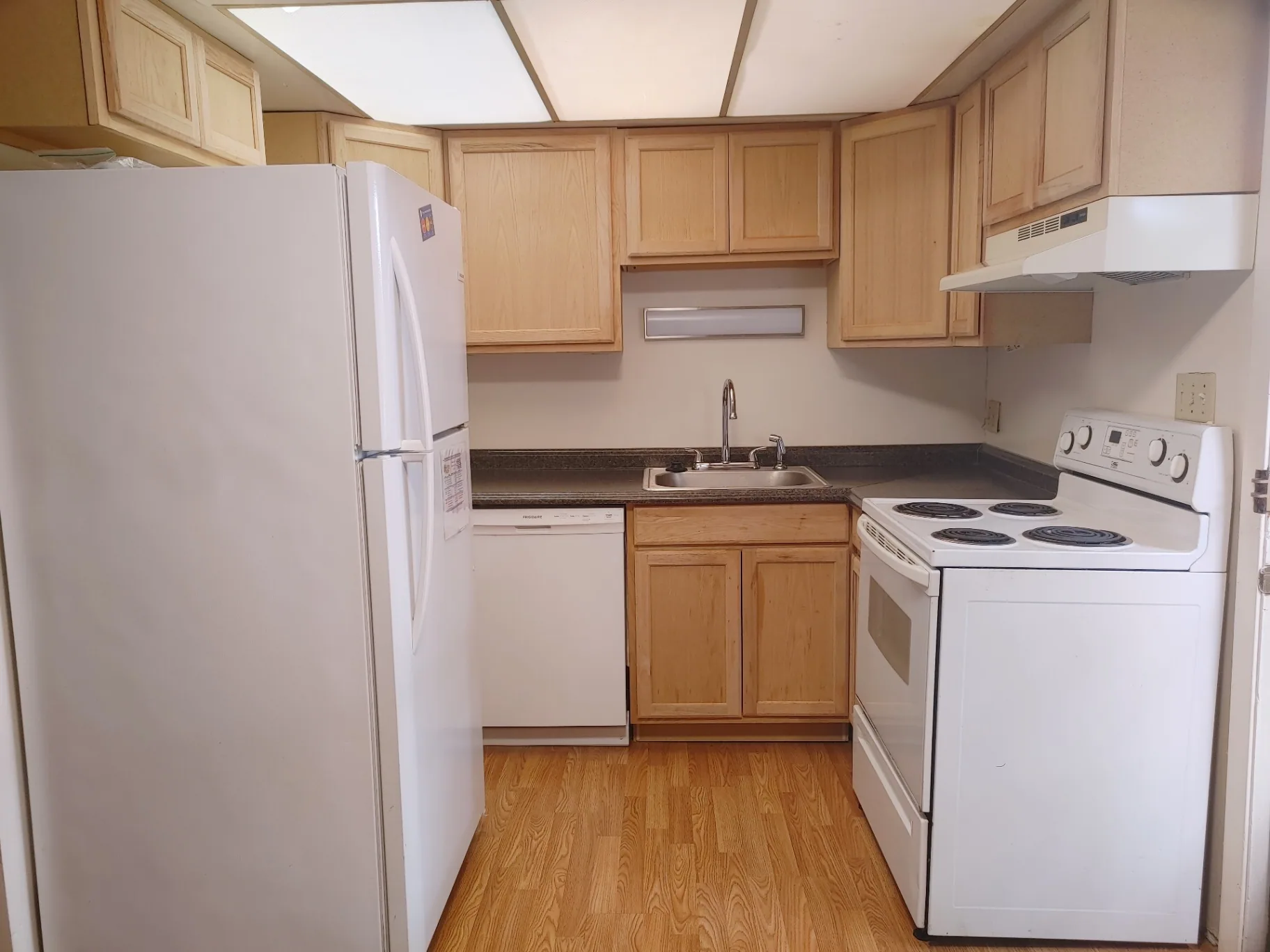 2016 Iuka Ave. kitchen with maple cabinets, white appliances, and bright overhead lighting