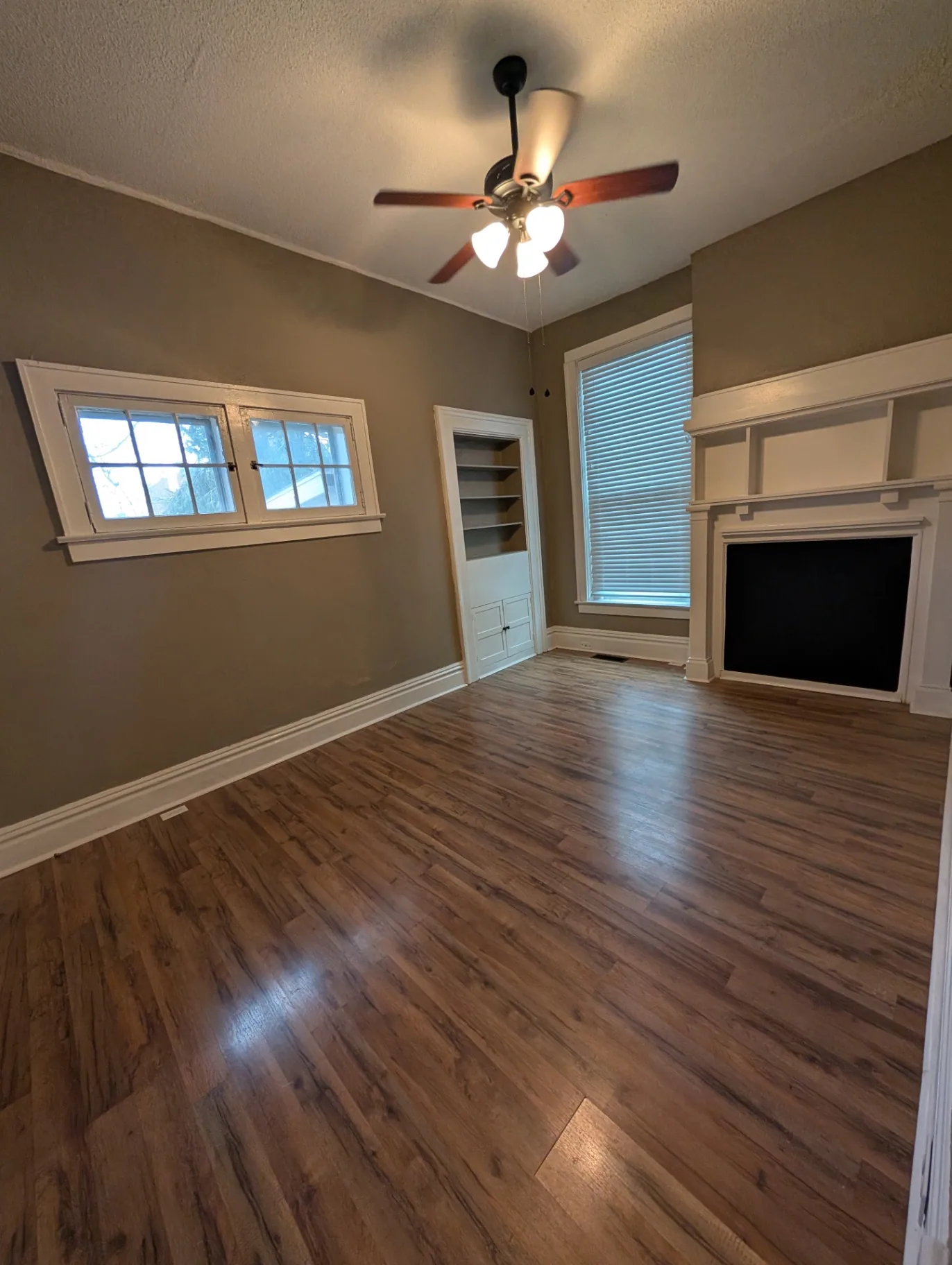 3338 Chestnut Downstairs living room with ceiling fan, built-in bookshelf and decorative mantel
