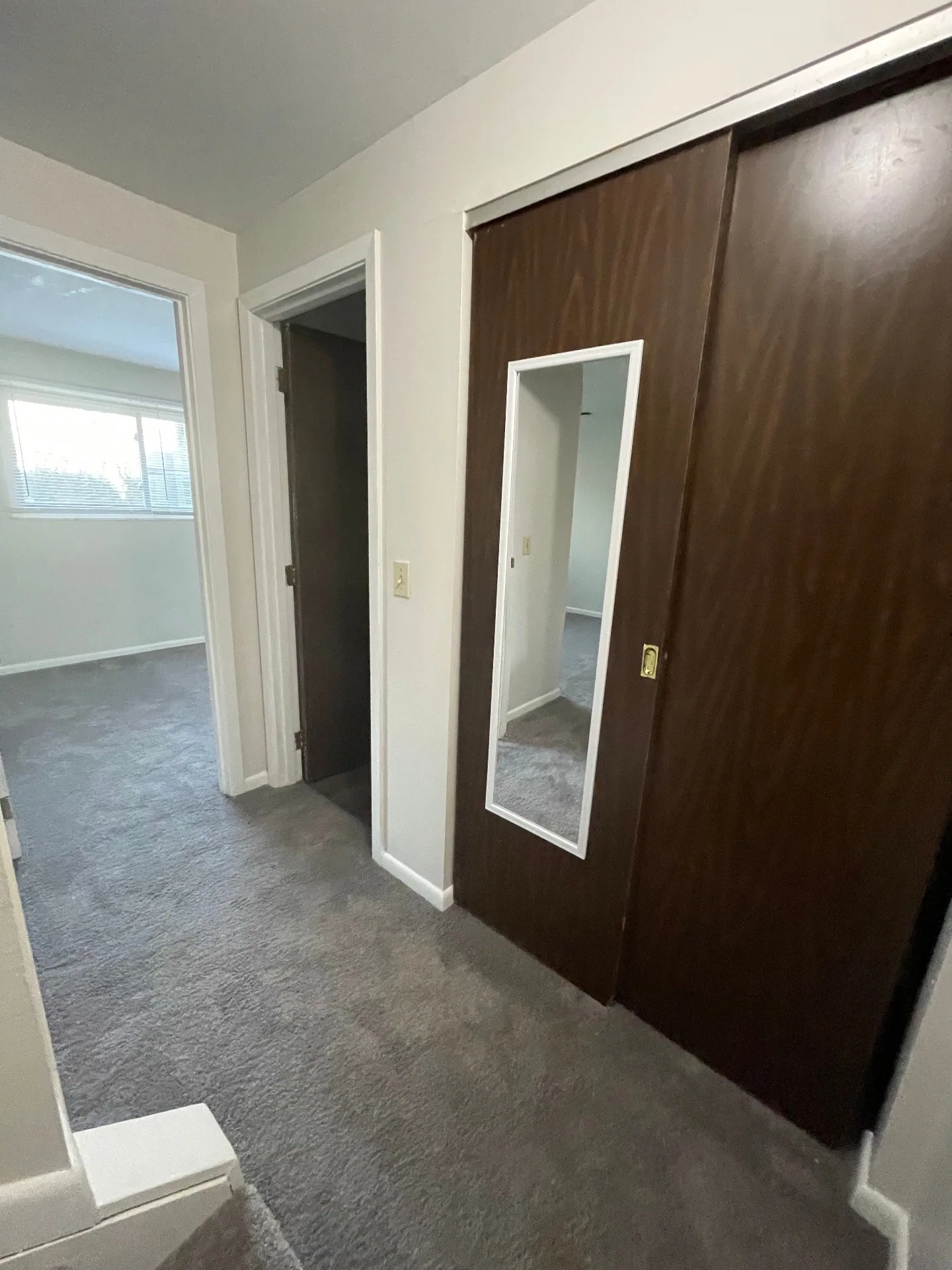 2020 Summit St. bedroom hallway with mirrored closet doors and fresh carpet