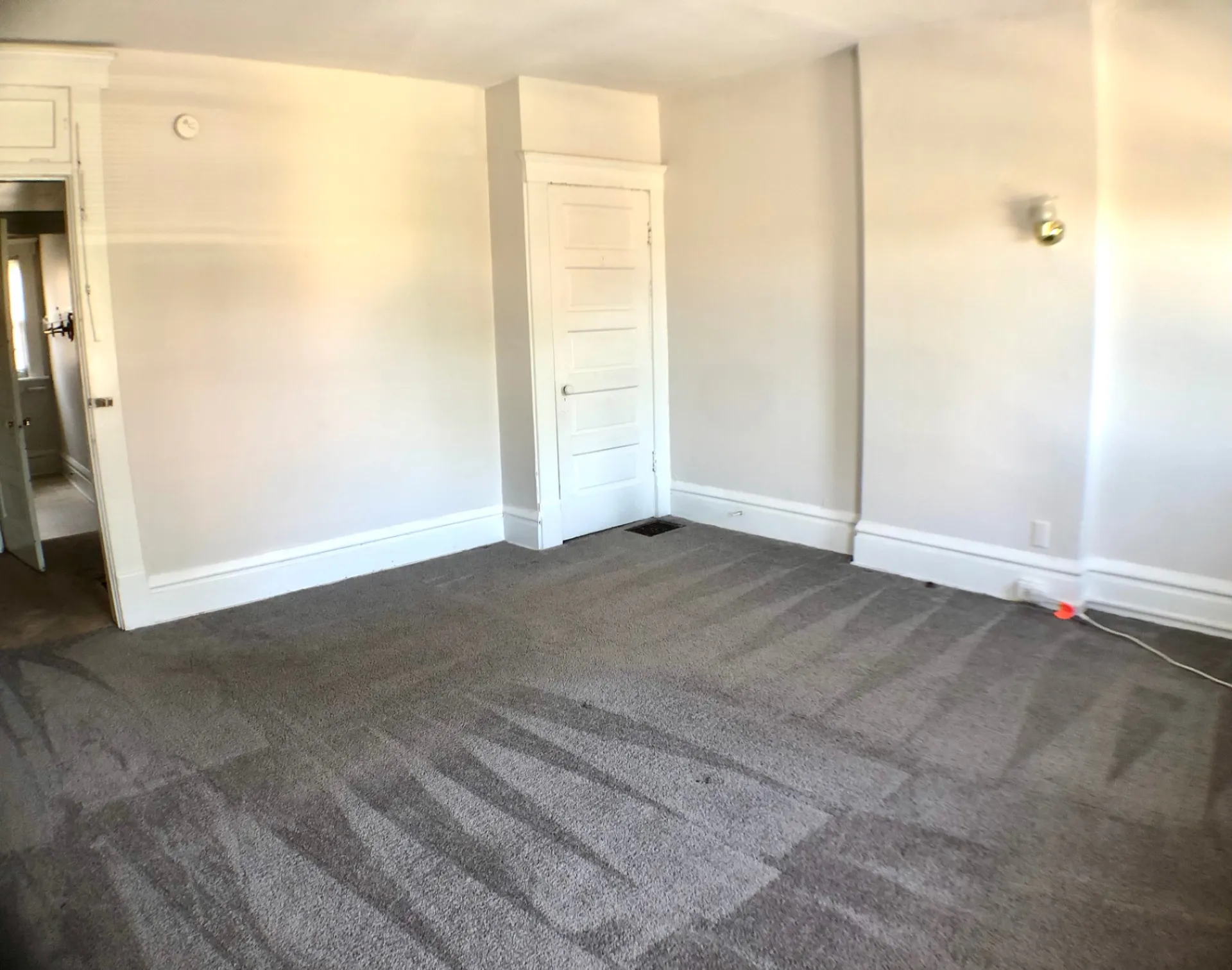 117 W 9th bedroom with plush carpet and wall sconce