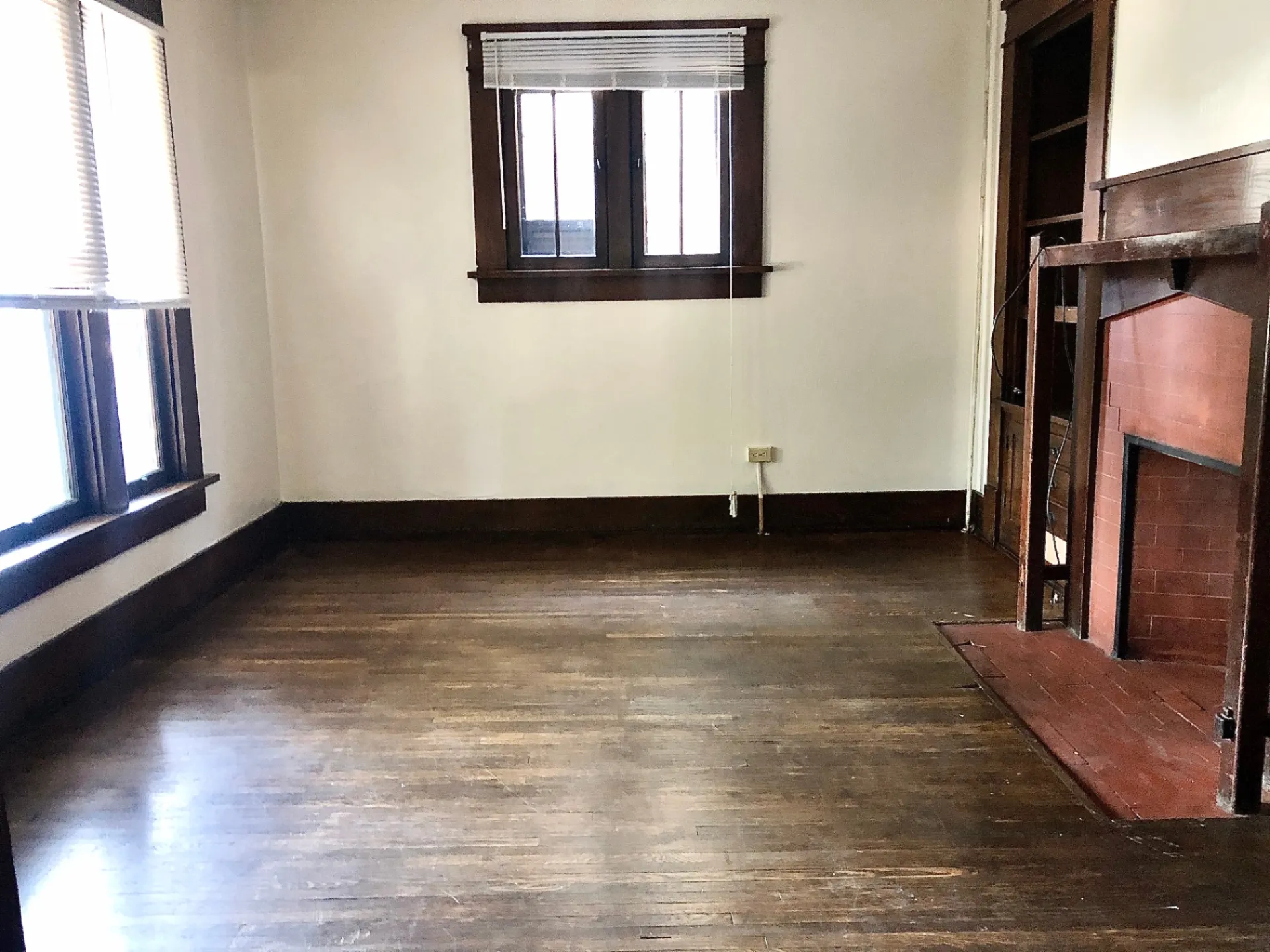 2015 Summit St. living space with hardwood floors, wood trim windows, and brick fireplace