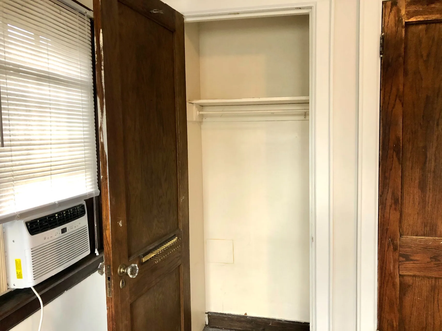 2044 Iuka Ave. B bedroom closet next to window AC unit and original wood door