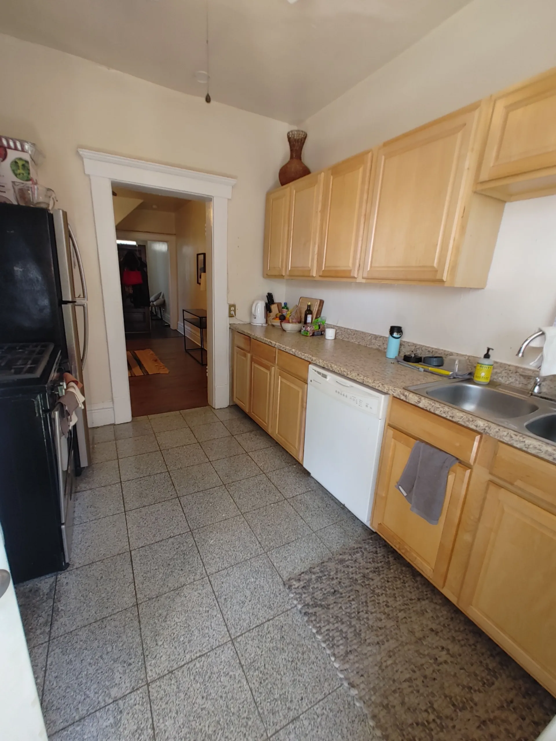 117 W 9th galley kitchen view with stainless refrigerator and dishwasher