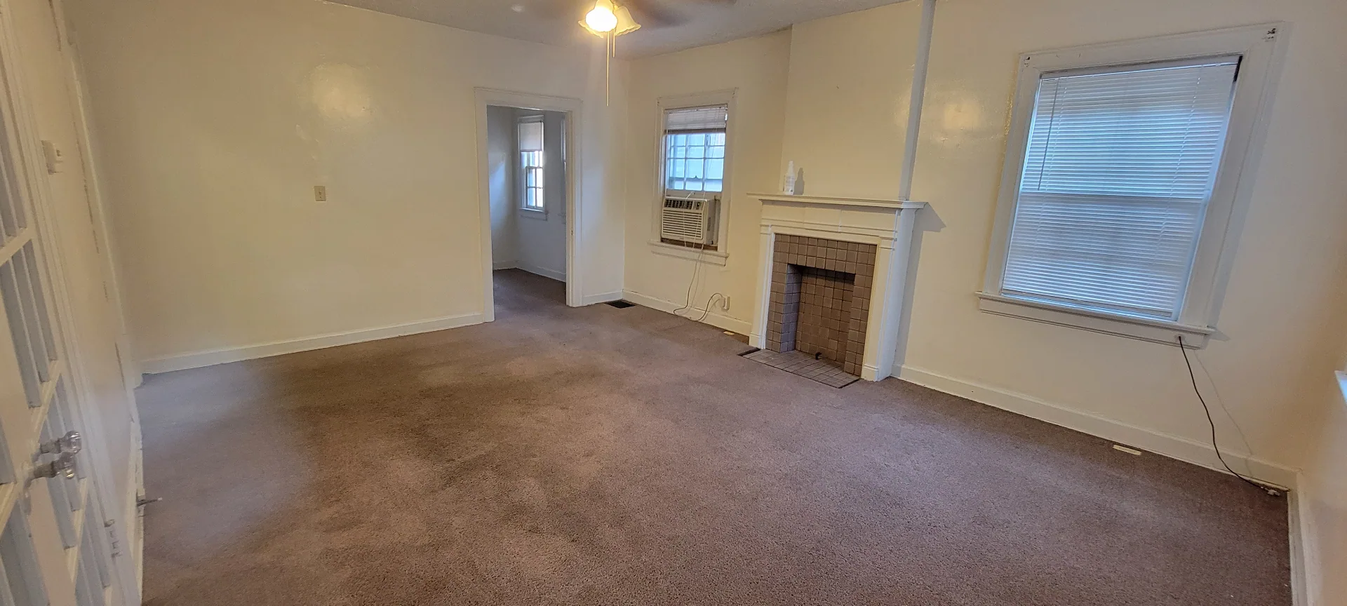 2044 Iuka Ave. D living room with decorative tile fireplace, ceiling fan, and window AC