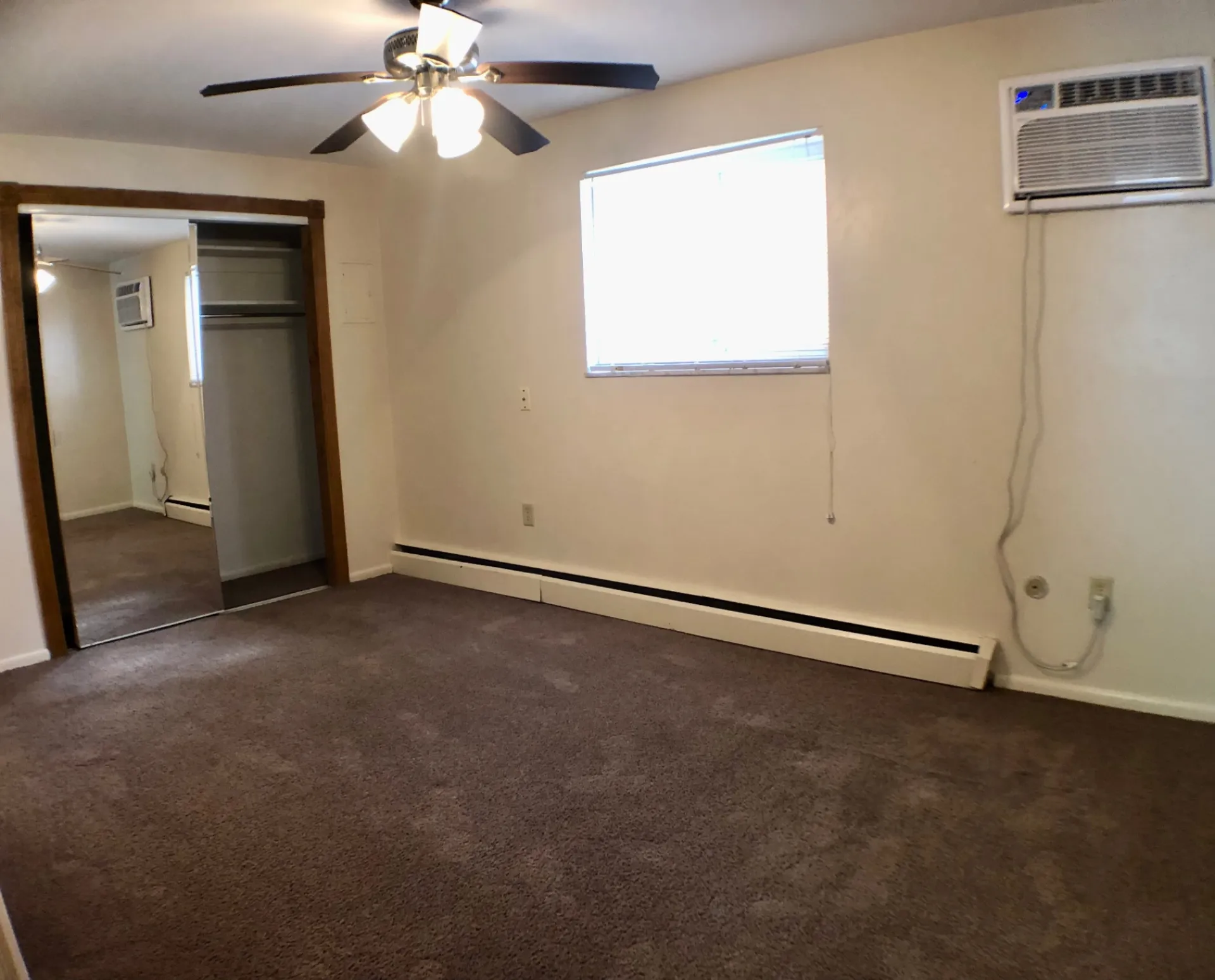 1827 N 4th St. Unit 1 carpeted bedroom with ceiling fan, closet, and window AC