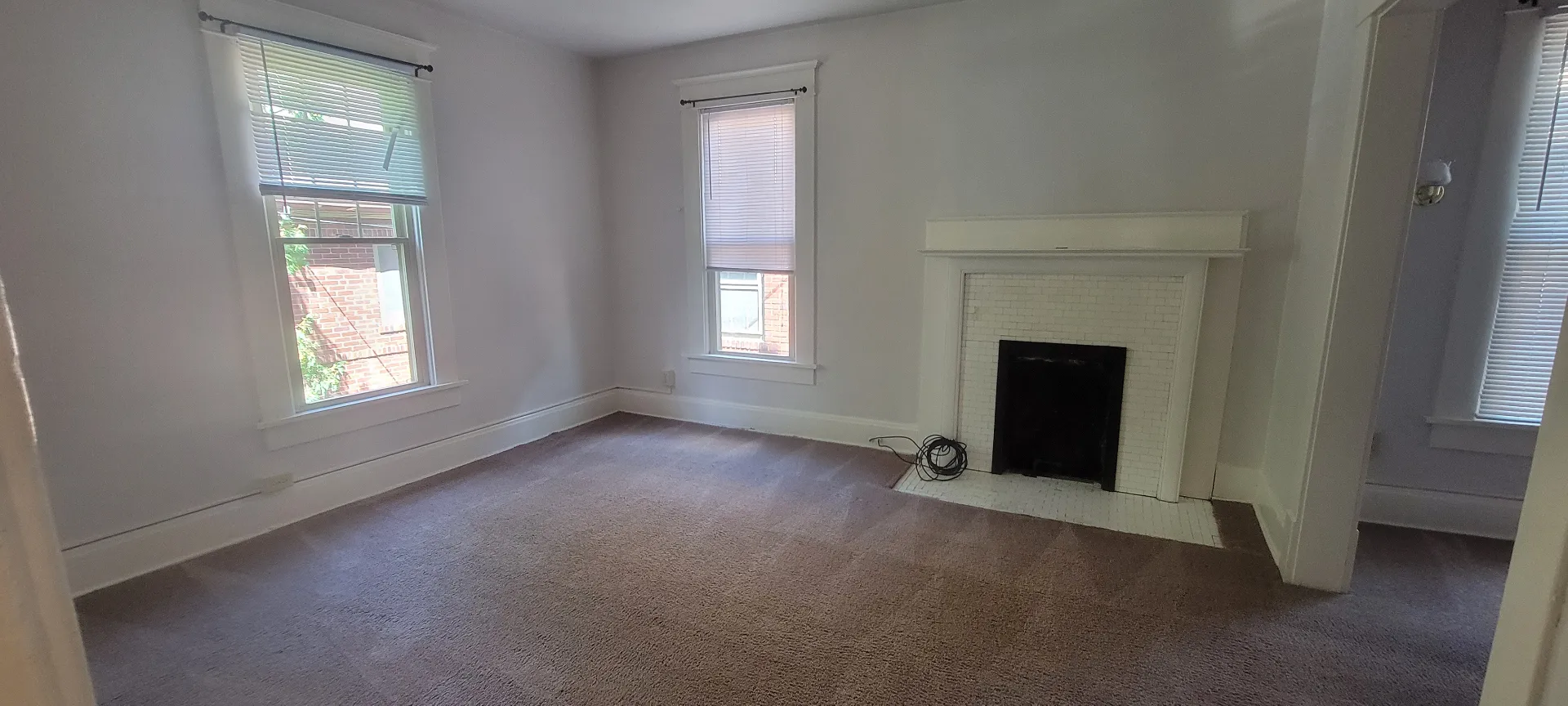 2015 Summit St. upstairs bedroom with white tile fireplace, carpet, and tall windows