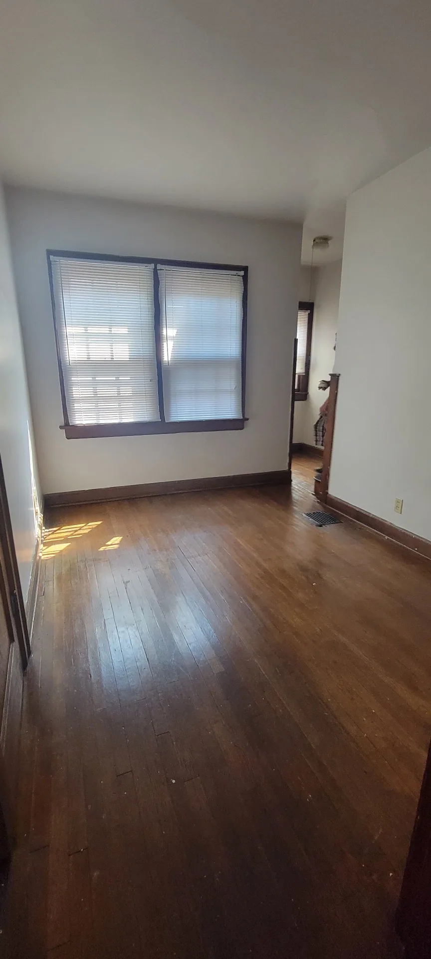 2044 Iuka Ave. C bright bedroom with hardwood floors, wide double windows, and original wood trim