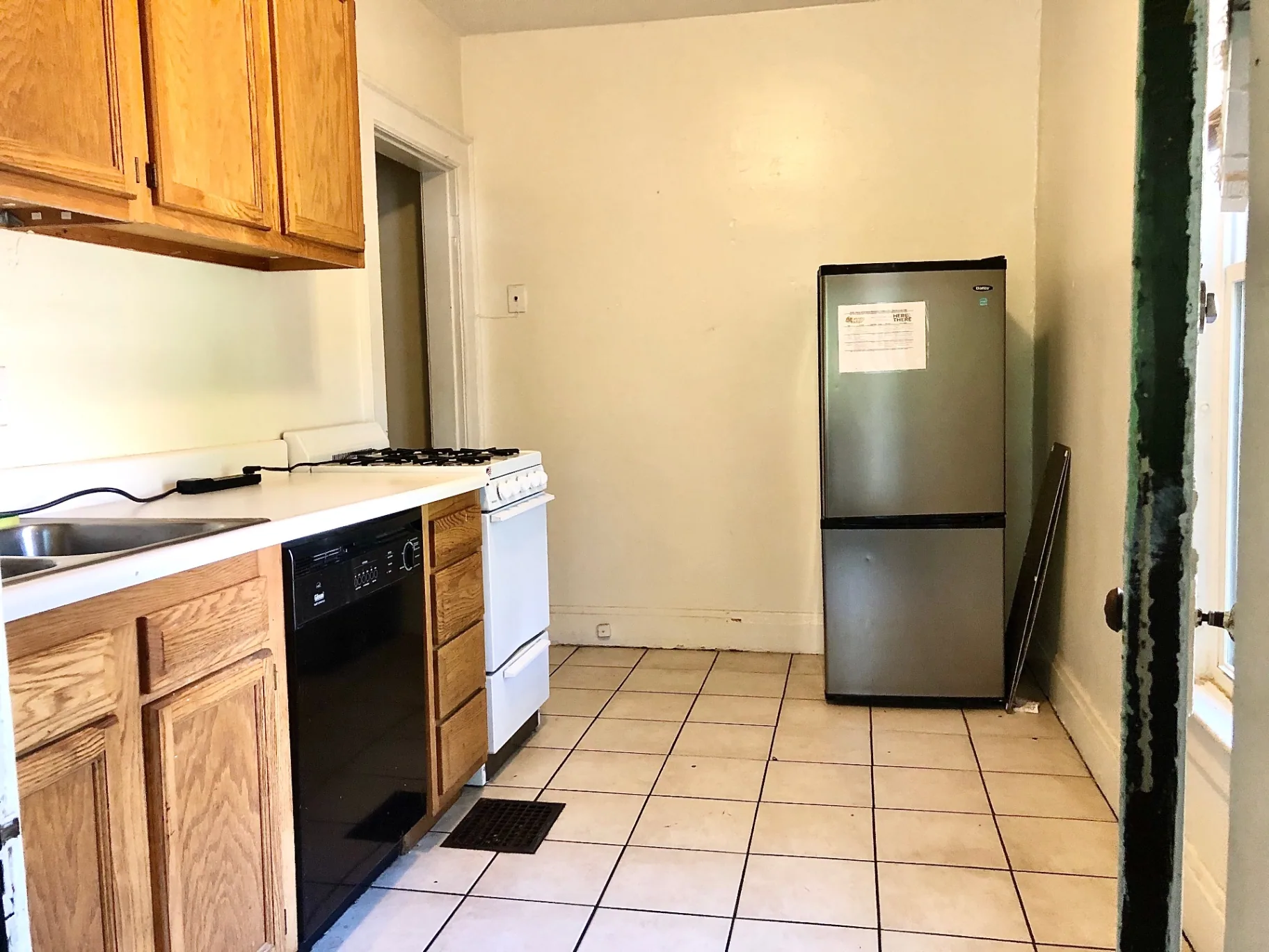 372 B E 14th Ave. kitchen with oak cabinets, dishwasher, gas range, and stainless fridge