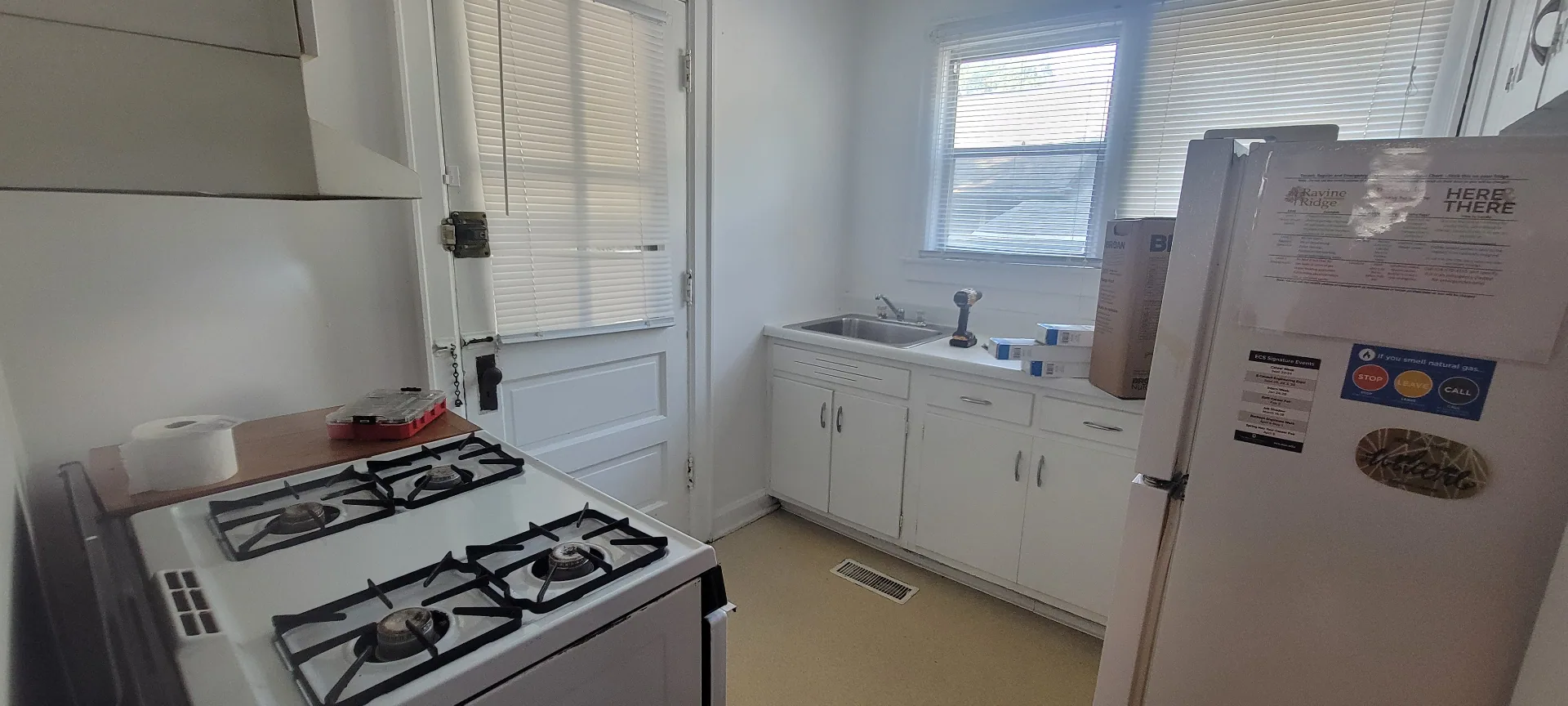 2044 Iuka Ave. C kitchen with gas range, white cabinetry, refrigerator, and rear exterior door