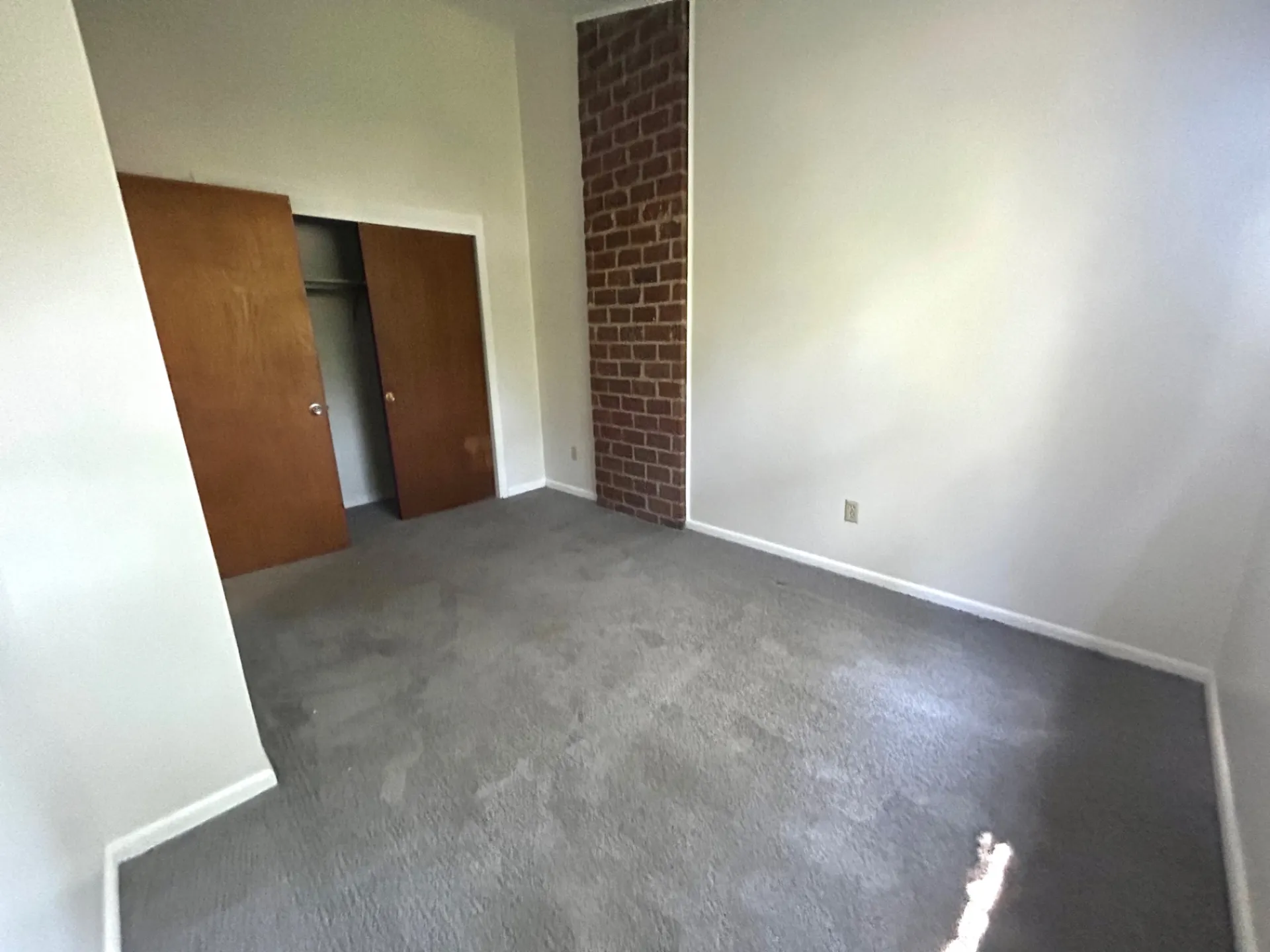 2011 Summit St. Unit E second bedroom with exposed brick accent and open closet